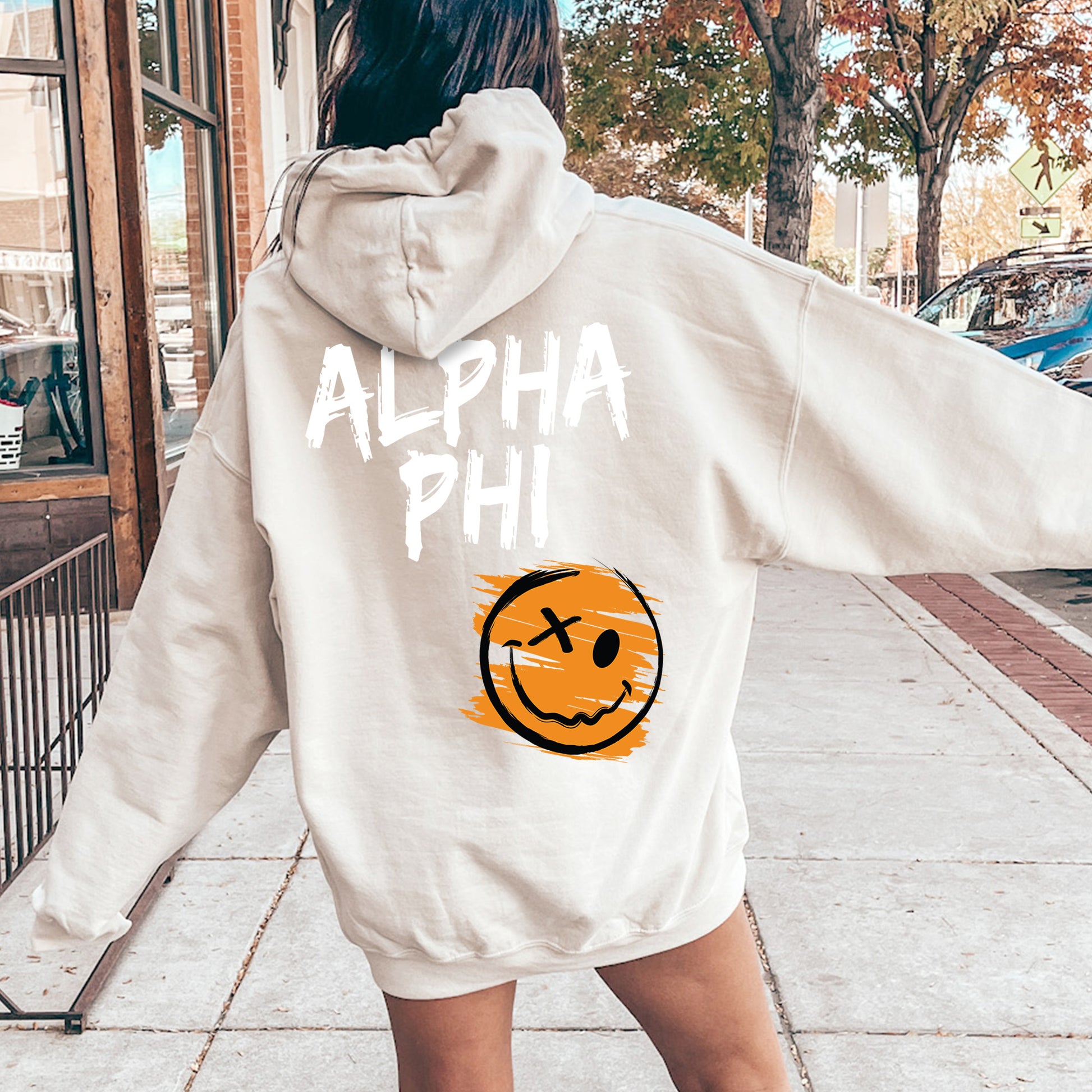 a woman in a white sweatshirt with a smiley face on it