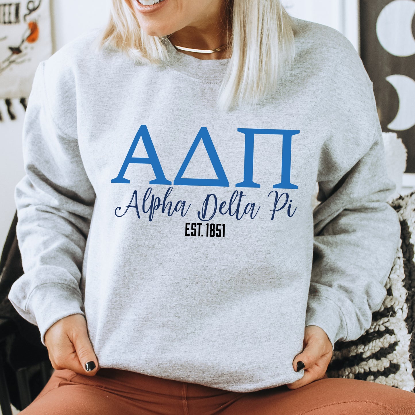 a woman sitting on a chair wearing a sweatshirt