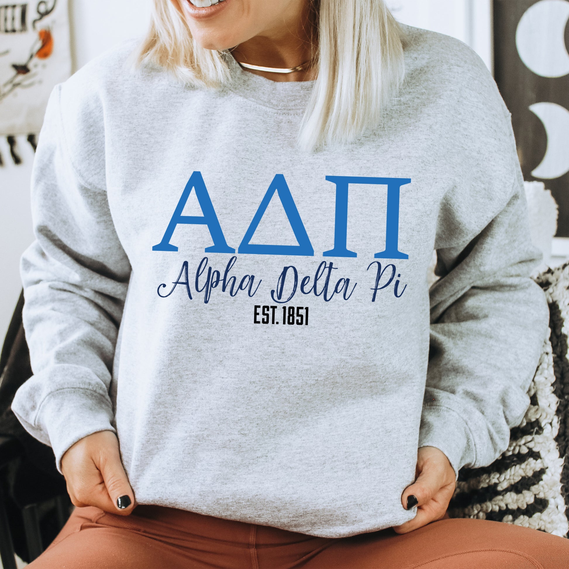 a woman sitting on a chair wearing a sweatshirt