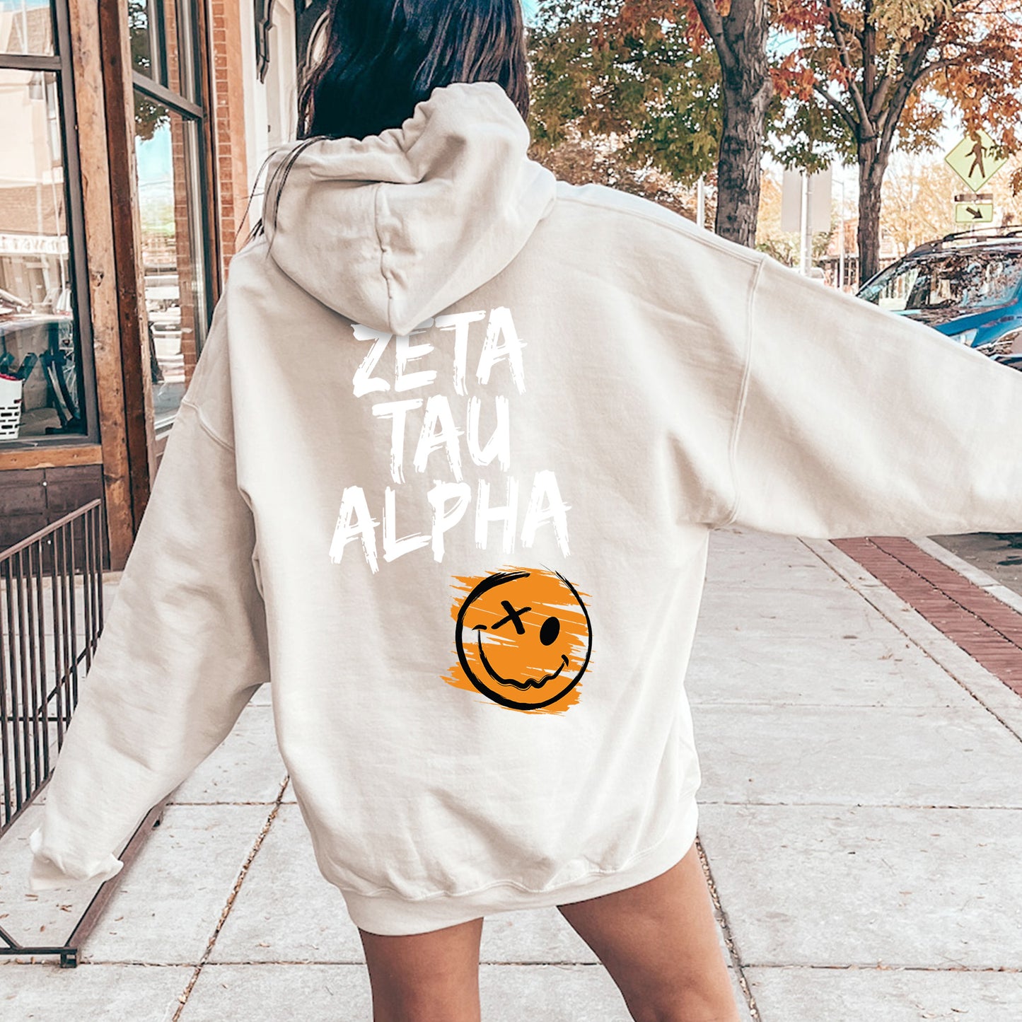 a woman in a white hoodie with a smiley face on it