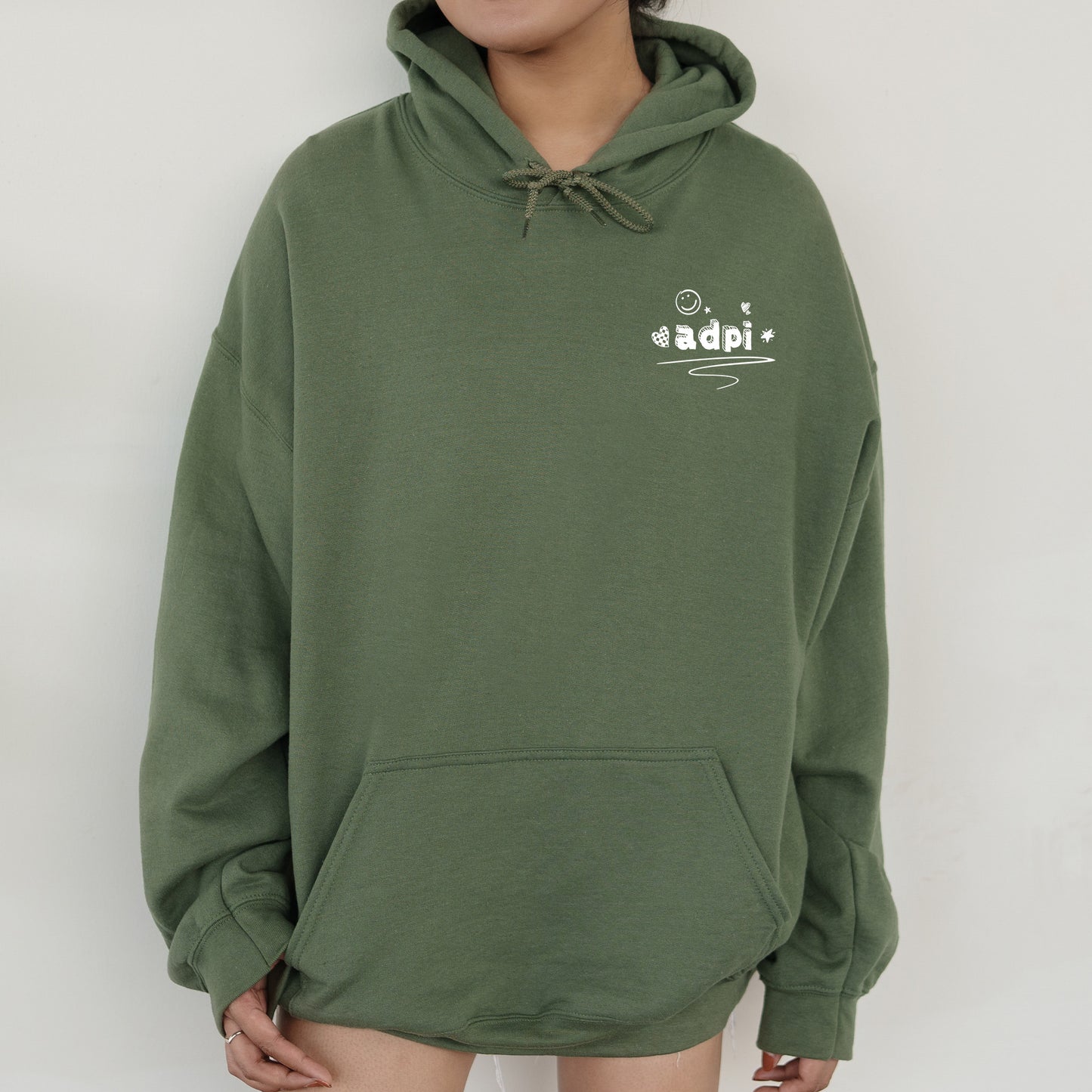 a person wearing a green hoodie with a white logo on it