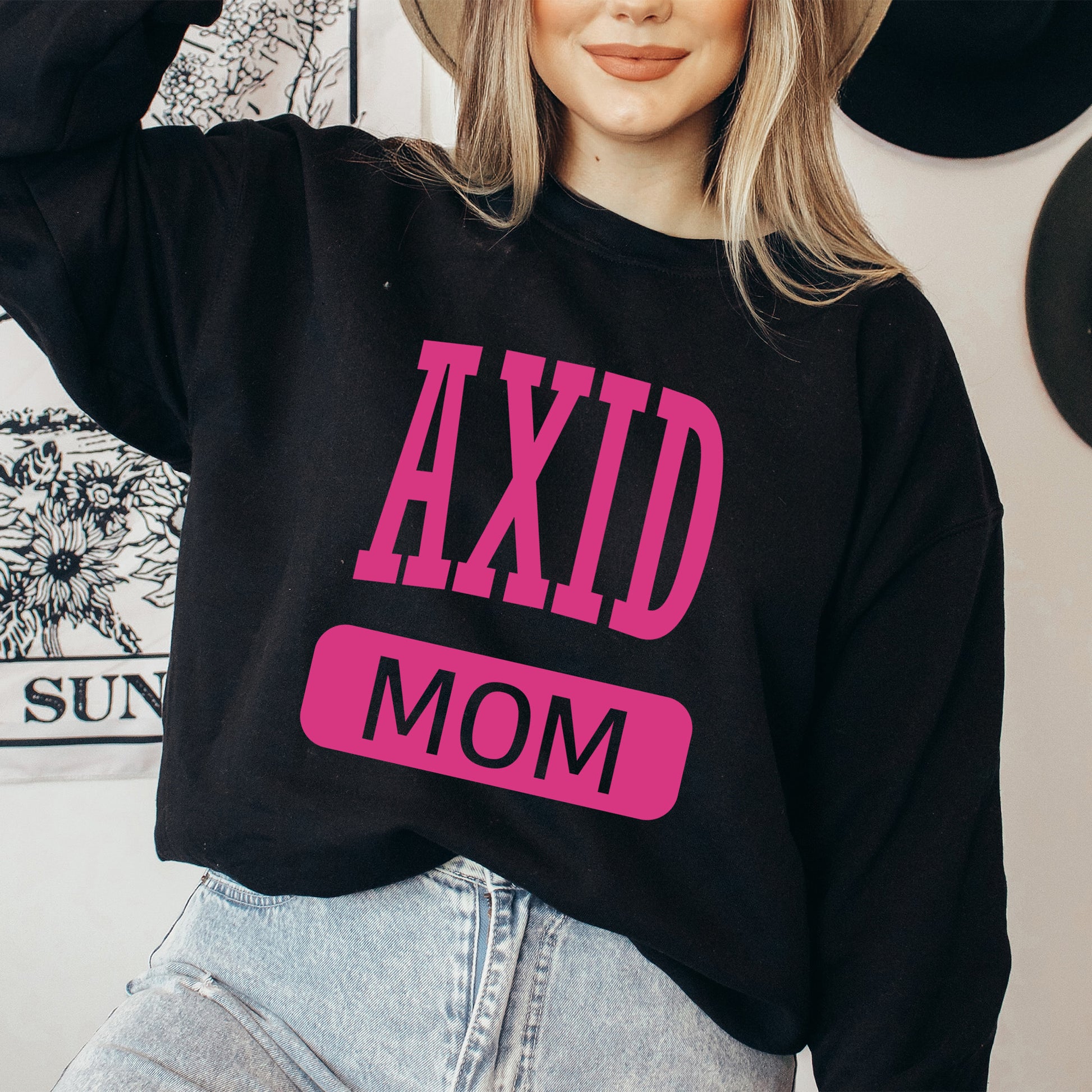 a woman wearing a sweatshirt that says axd mom