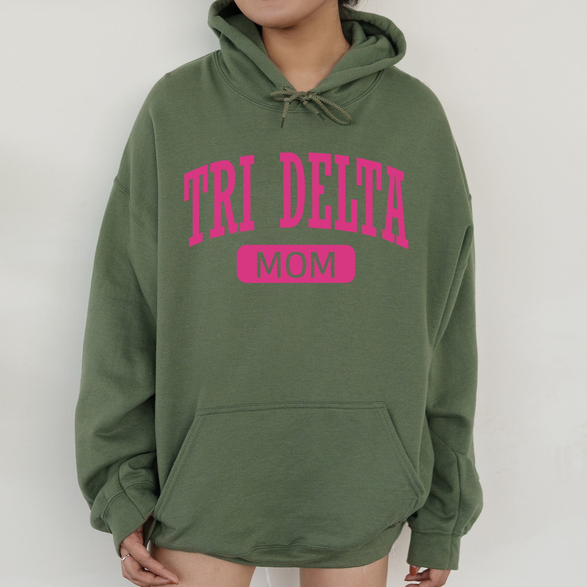 a woman wearing a green hoodie that says tri delta mom