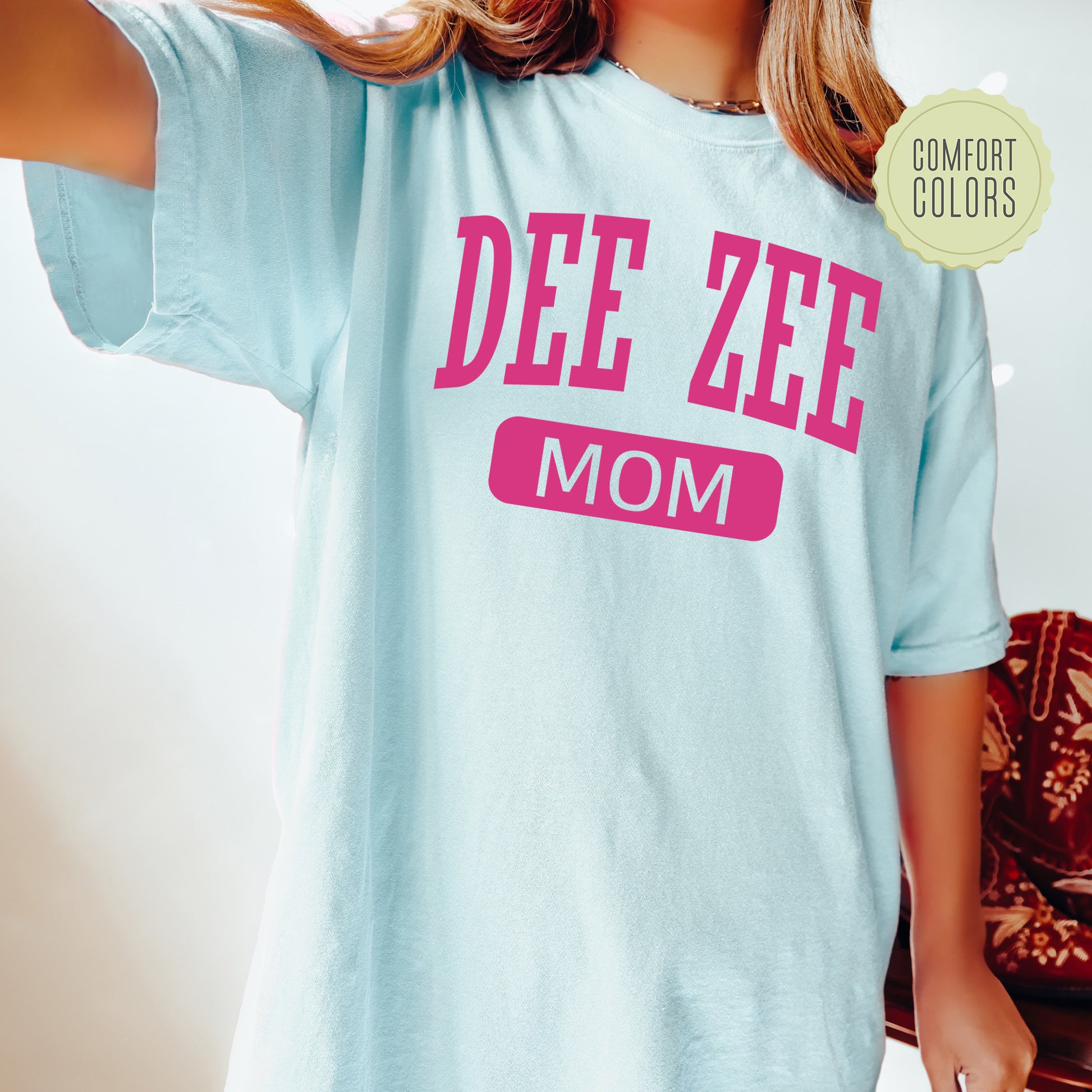 a woman wearing a blue tee shirt that says dee zeee mom