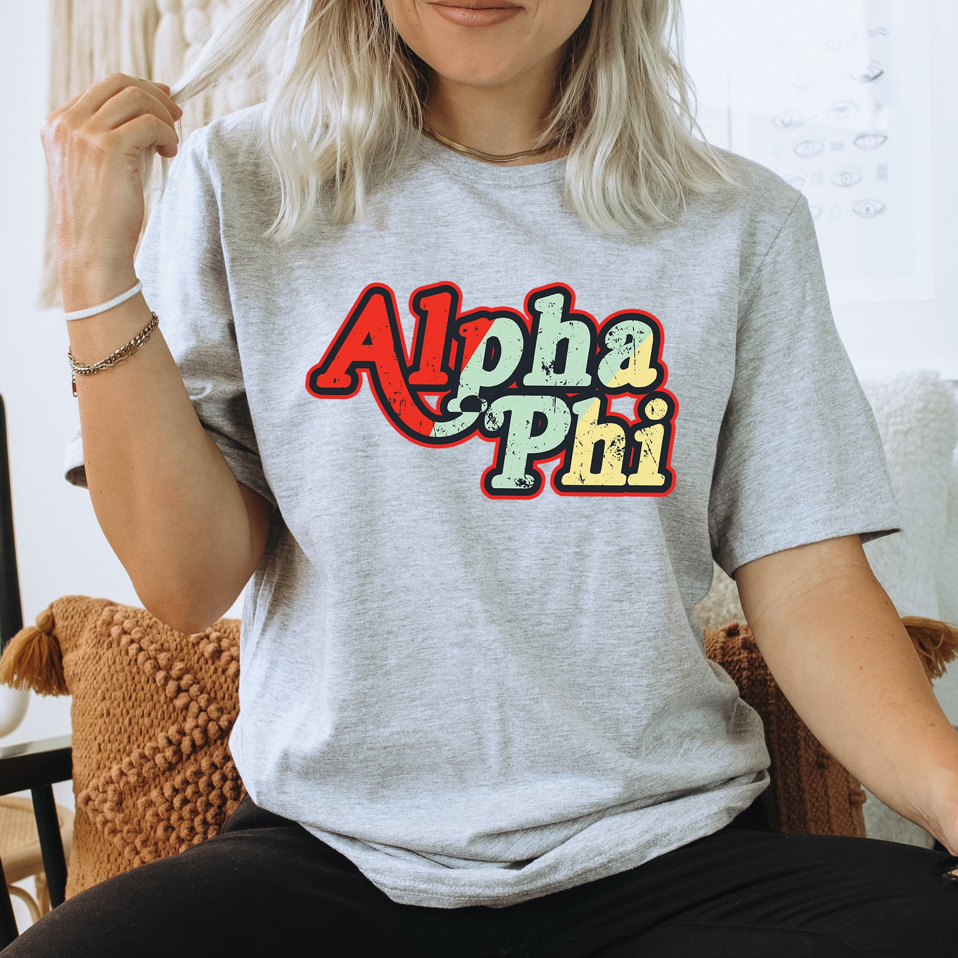 a woman sitting on a chair wearing a shirt that says aloha phi