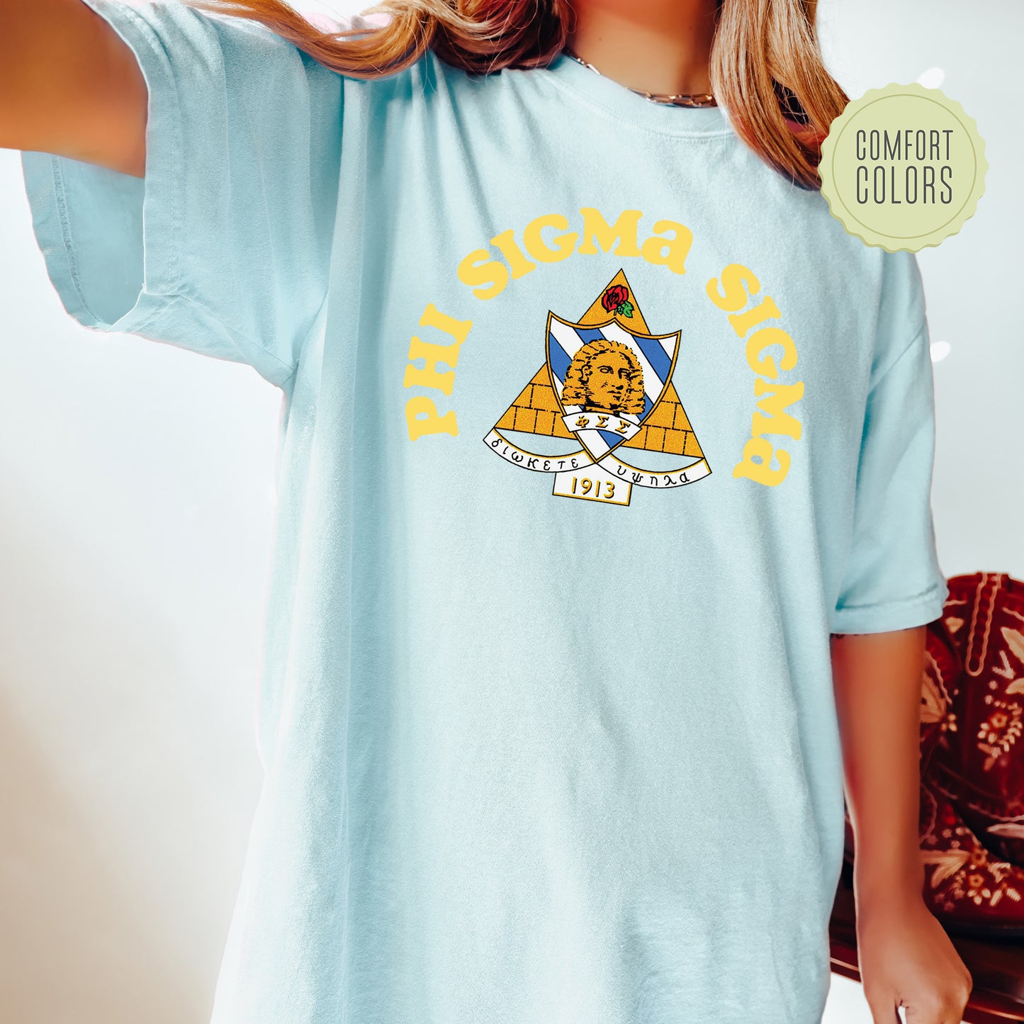a young girl wearing a blue shirt with a yellow and blue design on it