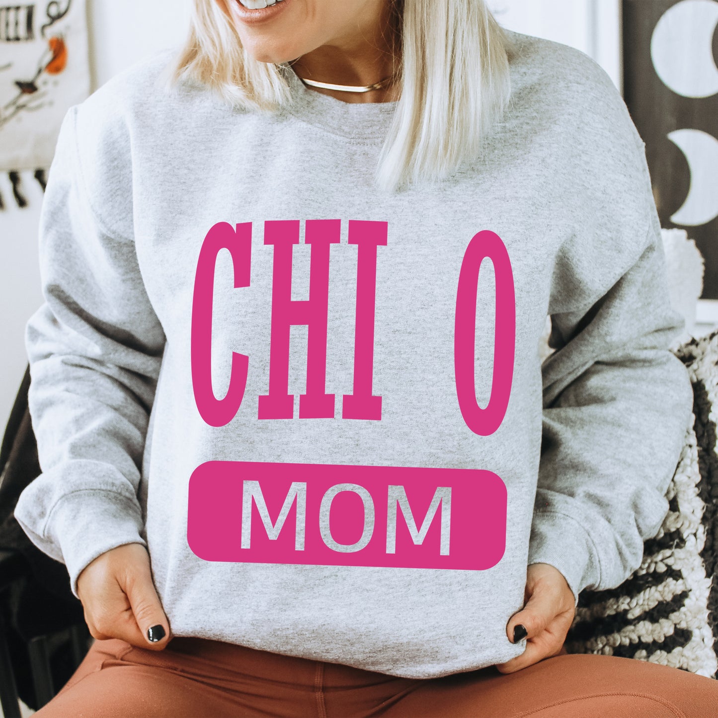 a woman wearing a sweatshirt that says chio mom
