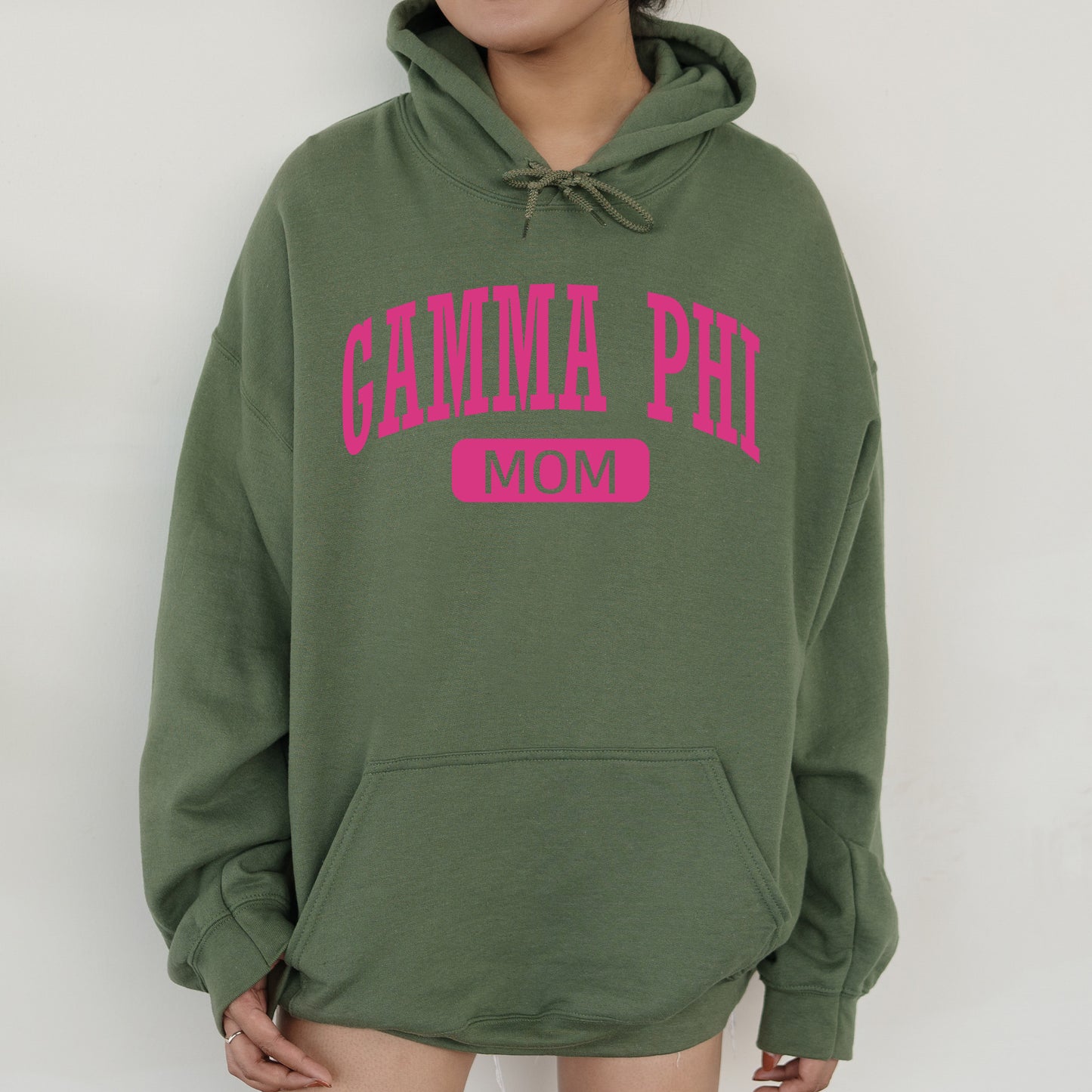 a woman wearing a green hoodie with pink lettering