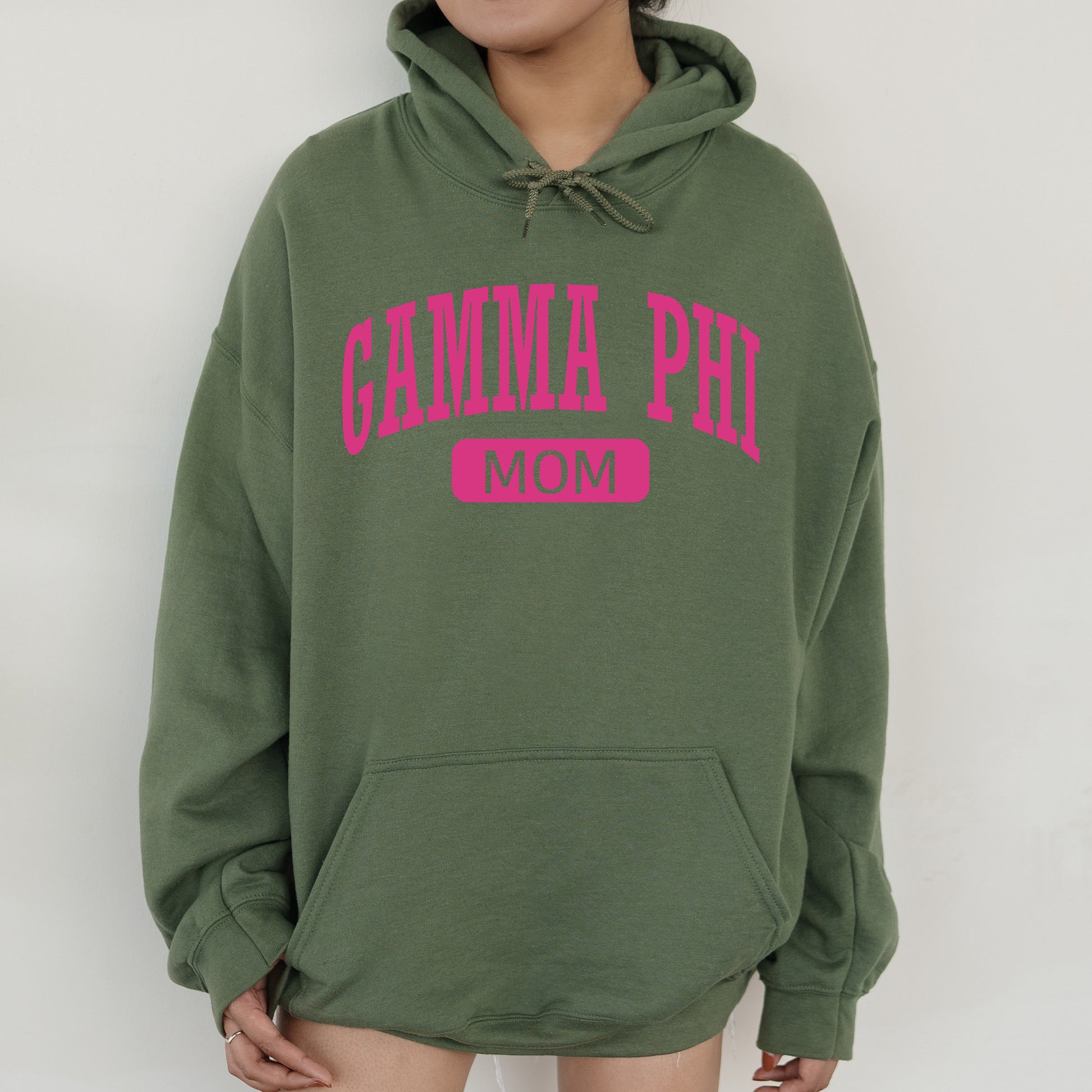 a woman wearing a green hoodie with pink lettering
