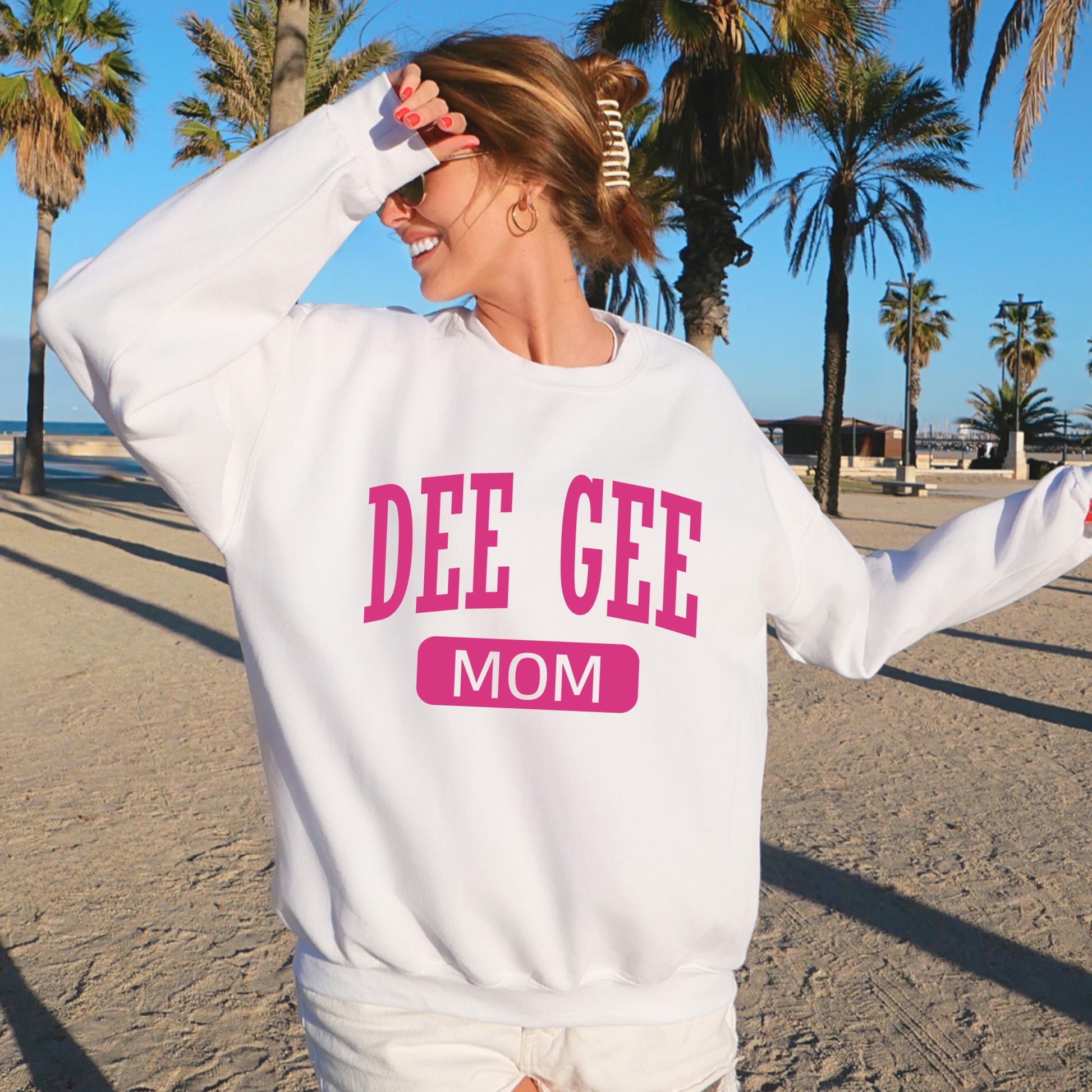 a woman wearing a sweatshirt that says dee gee mom
