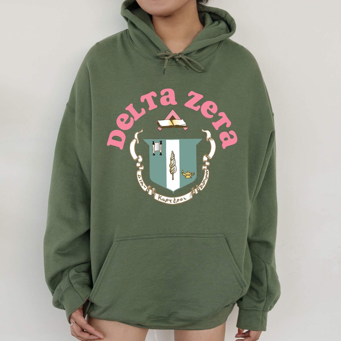 a person wearing a green hoodie with a crest on it