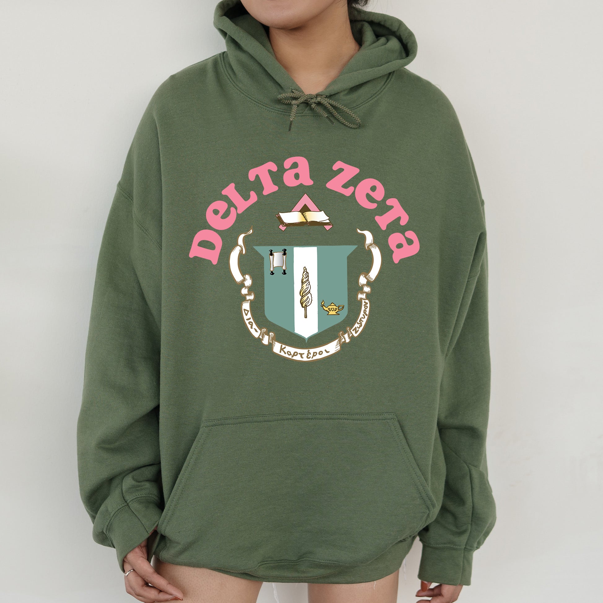 a person wearing a green hoodie with a crest on it