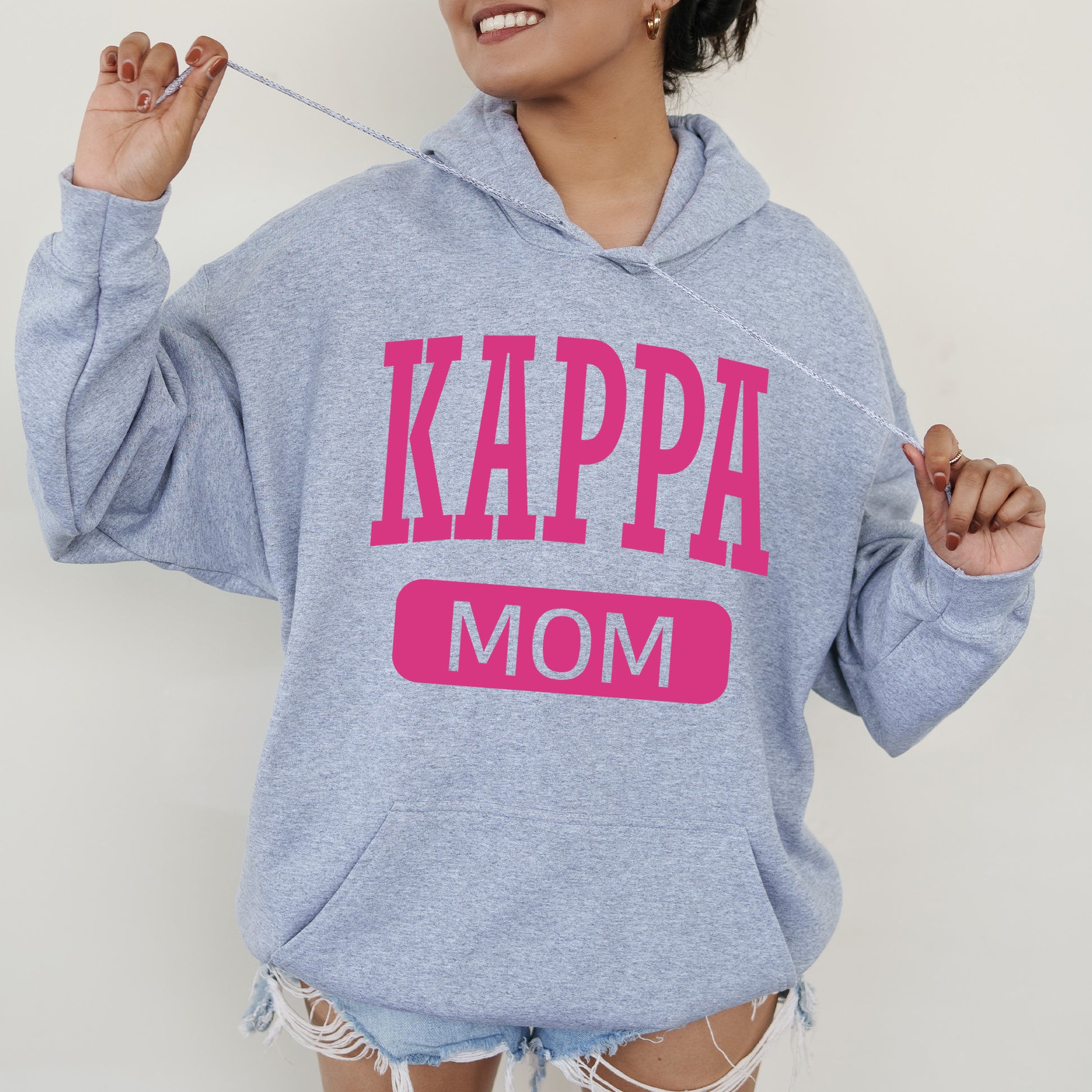 a woman wearing a sweatshirt that says kappa mom