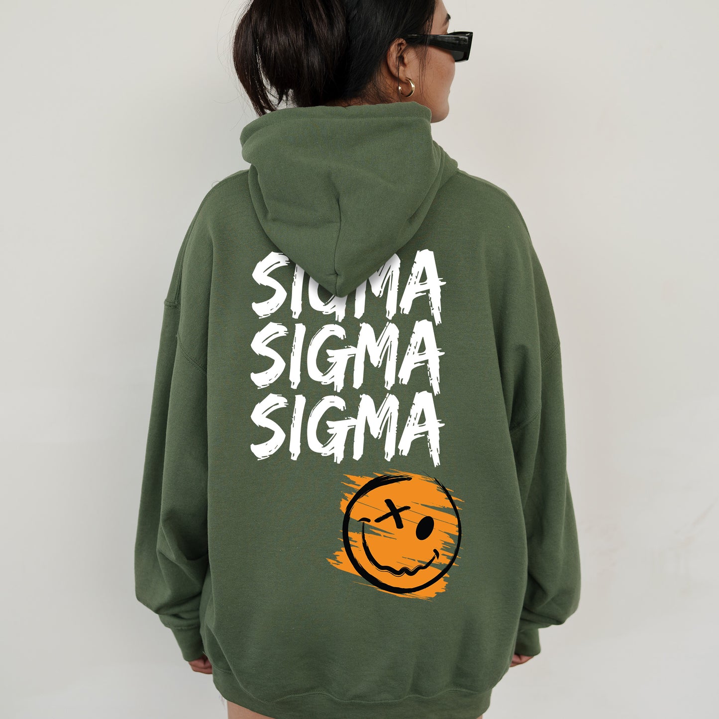 a woman wearing a green sweatshirt with a smiley face on it