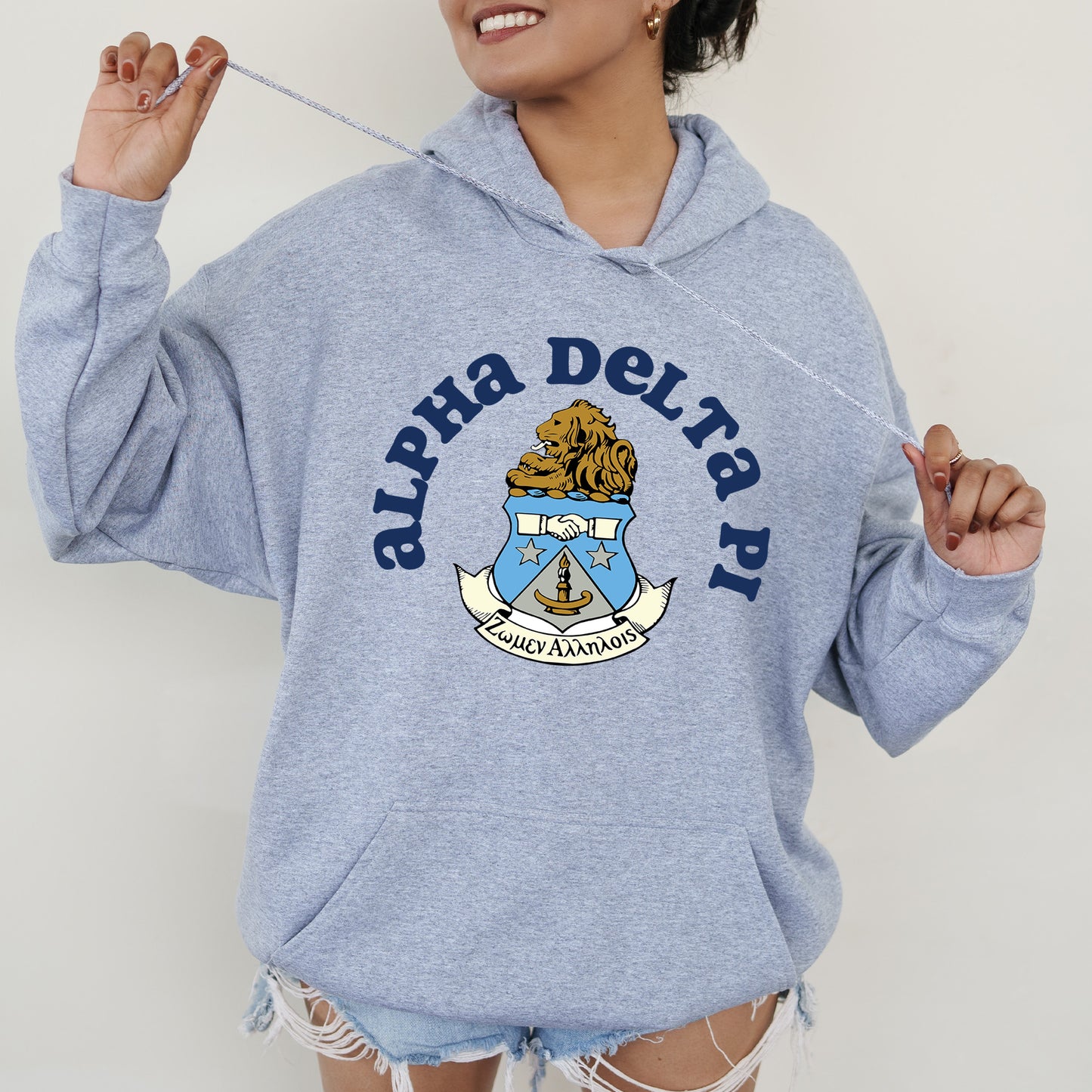 a woman in a blue sweatshirt holding a toothbrush