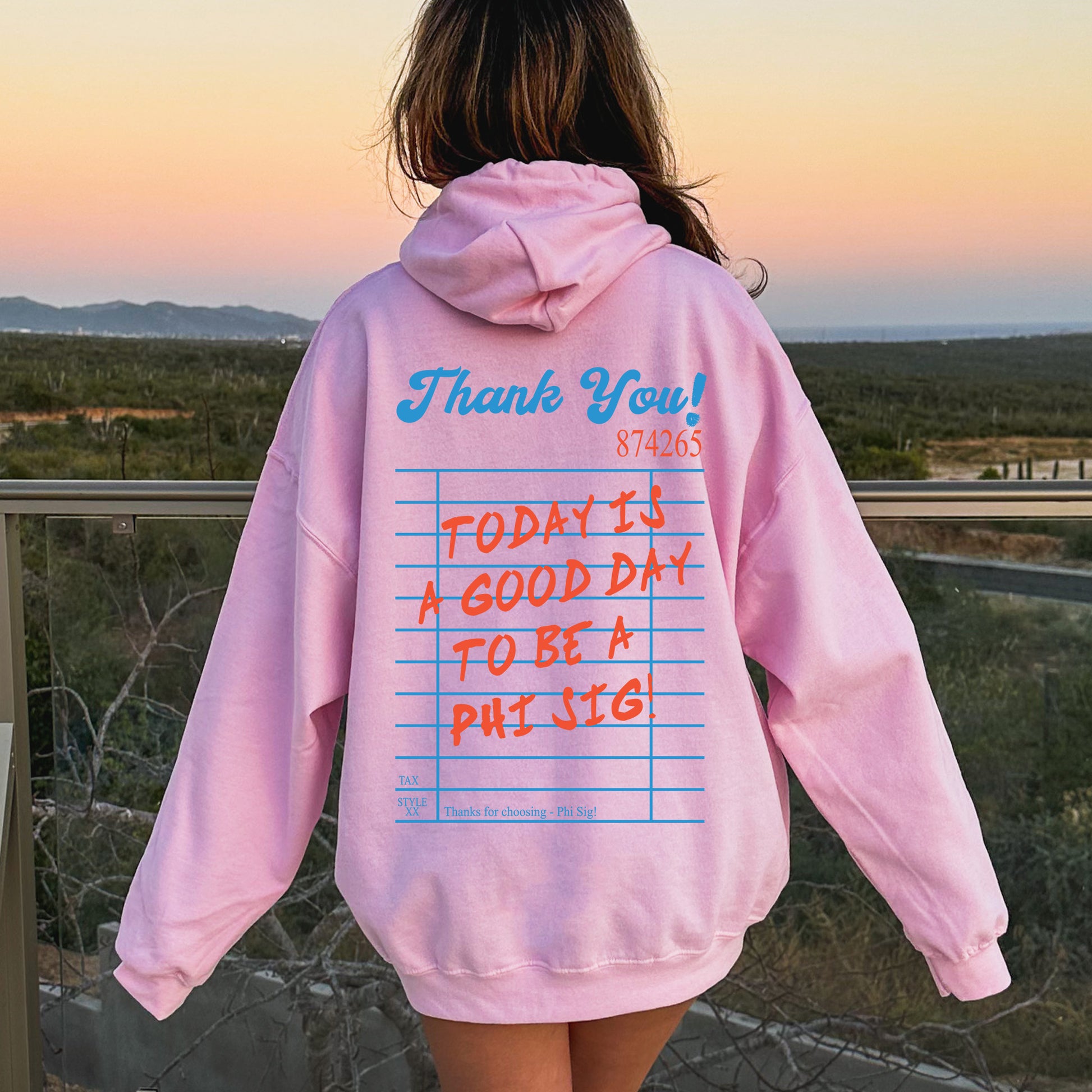 a person wearing a pink hoodie with writing on it