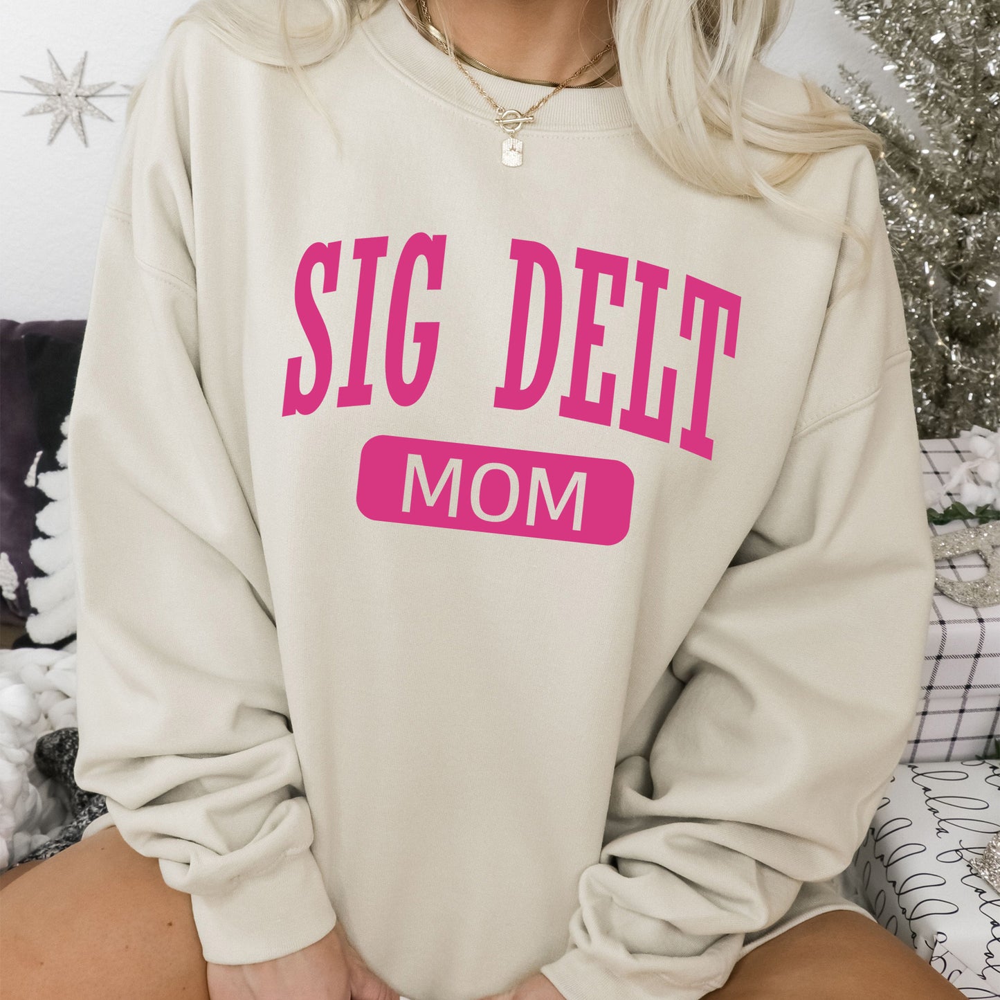 a woman sitting on a couch wearing a sweatshirt