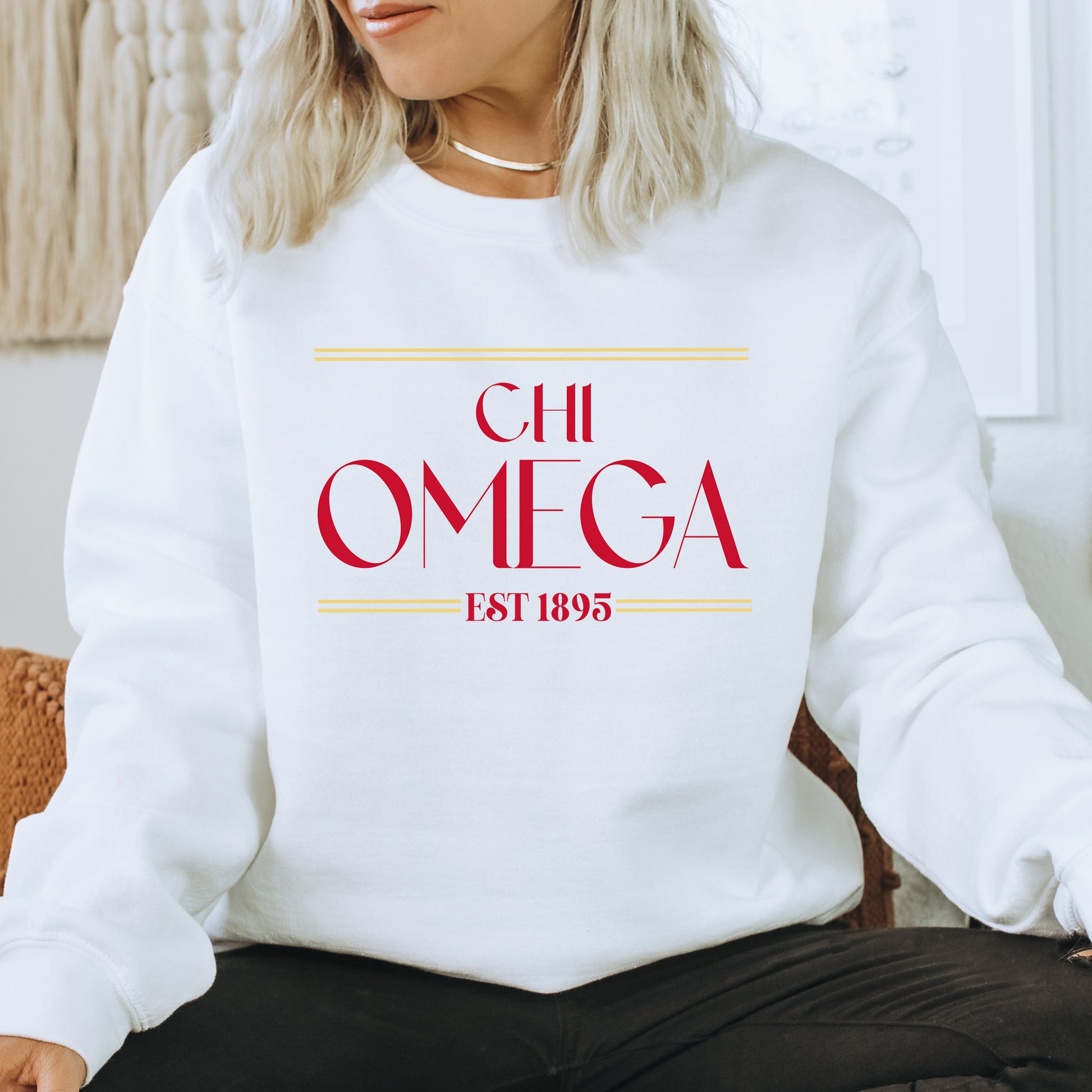 a woman sitting on a chair wearing a white sweatshirt