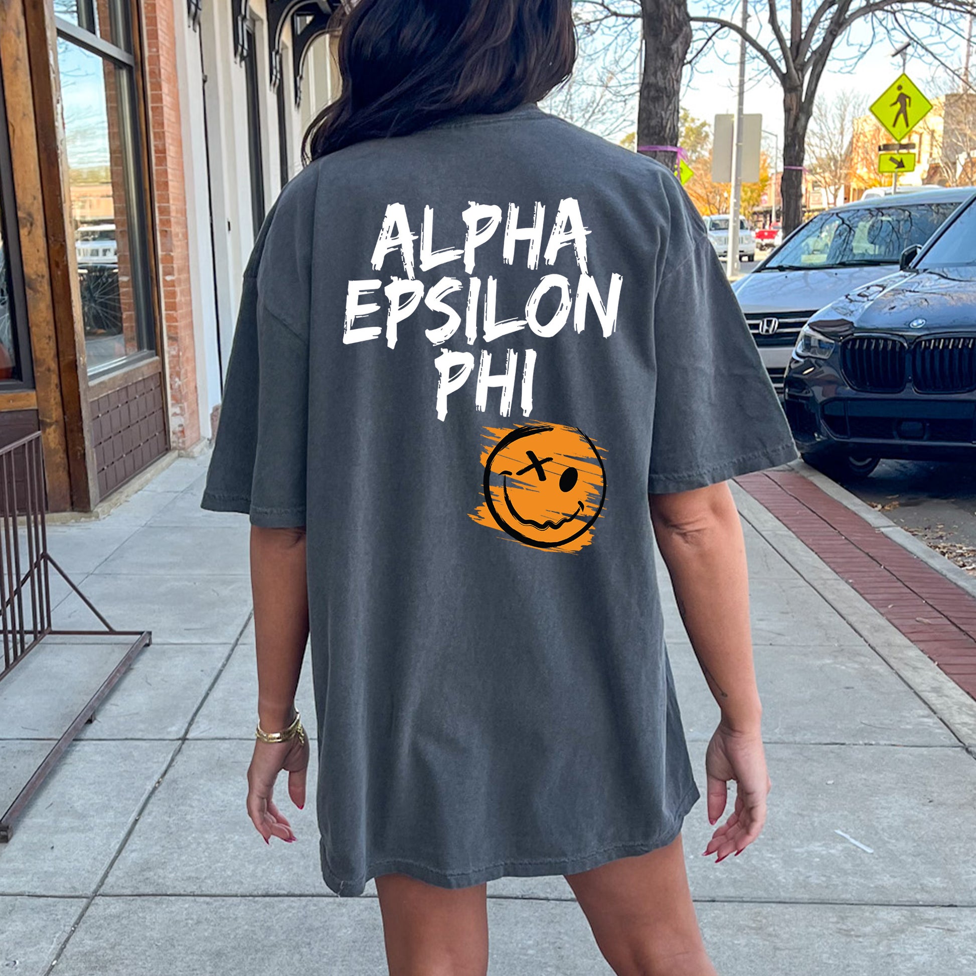 a woman walking down a sidewalk with a shirt on