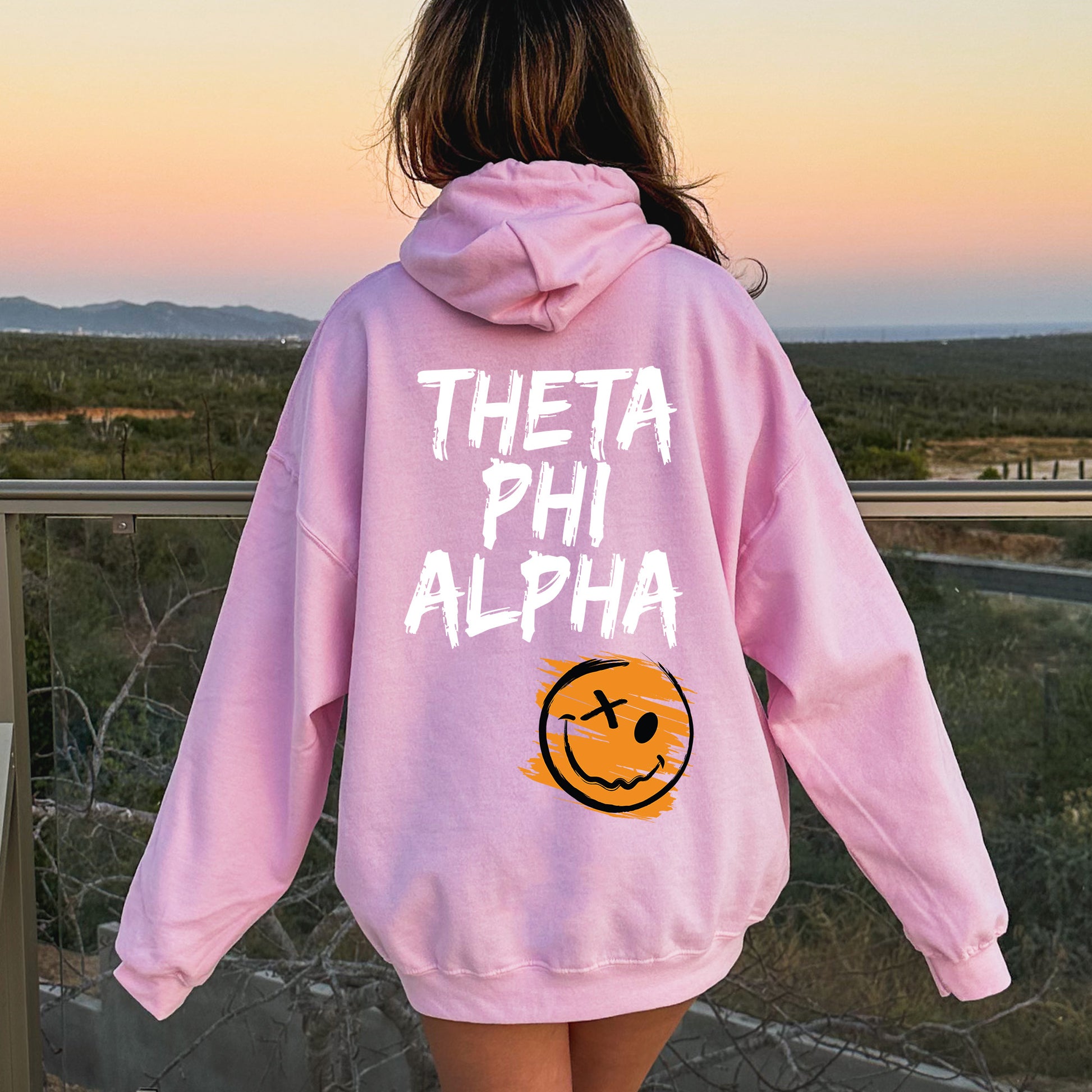 a girl in a pink hoodie that says, thea phi alpha