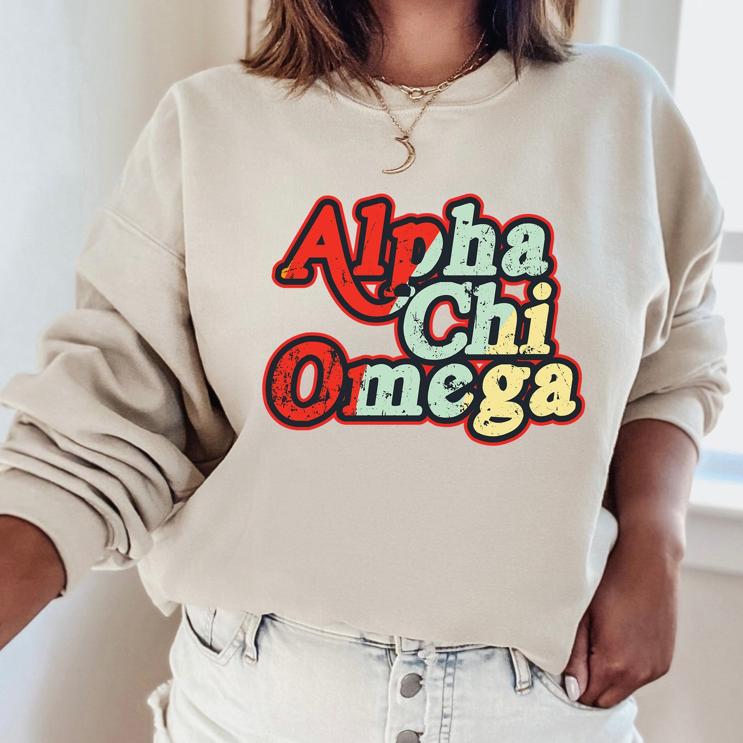 a woman wearing a sweatshirt with the word ahha chi omega printed on it