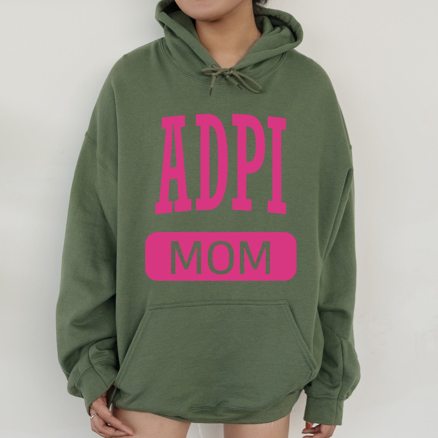a woman wearing a green hoodie with pink letters on it