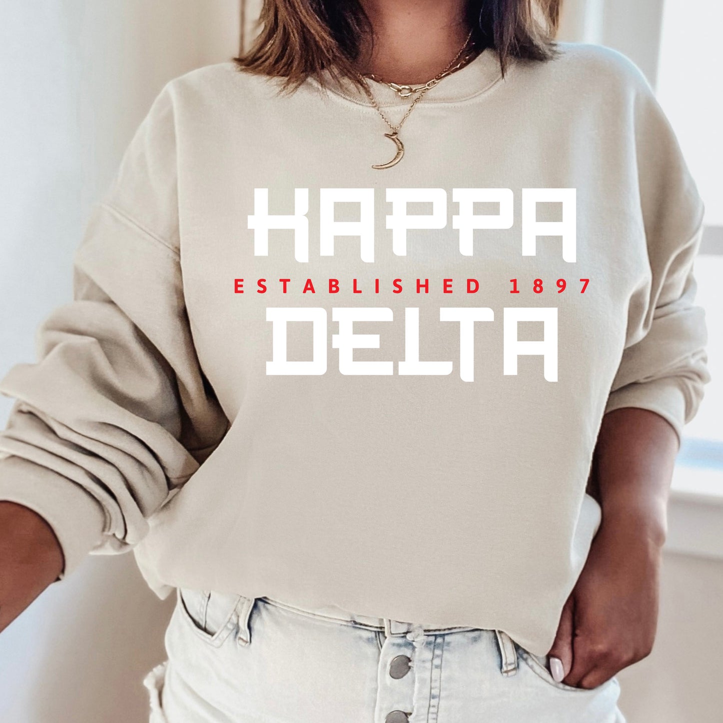 a woman wearing a sweatshirt that says happy delta established 1897