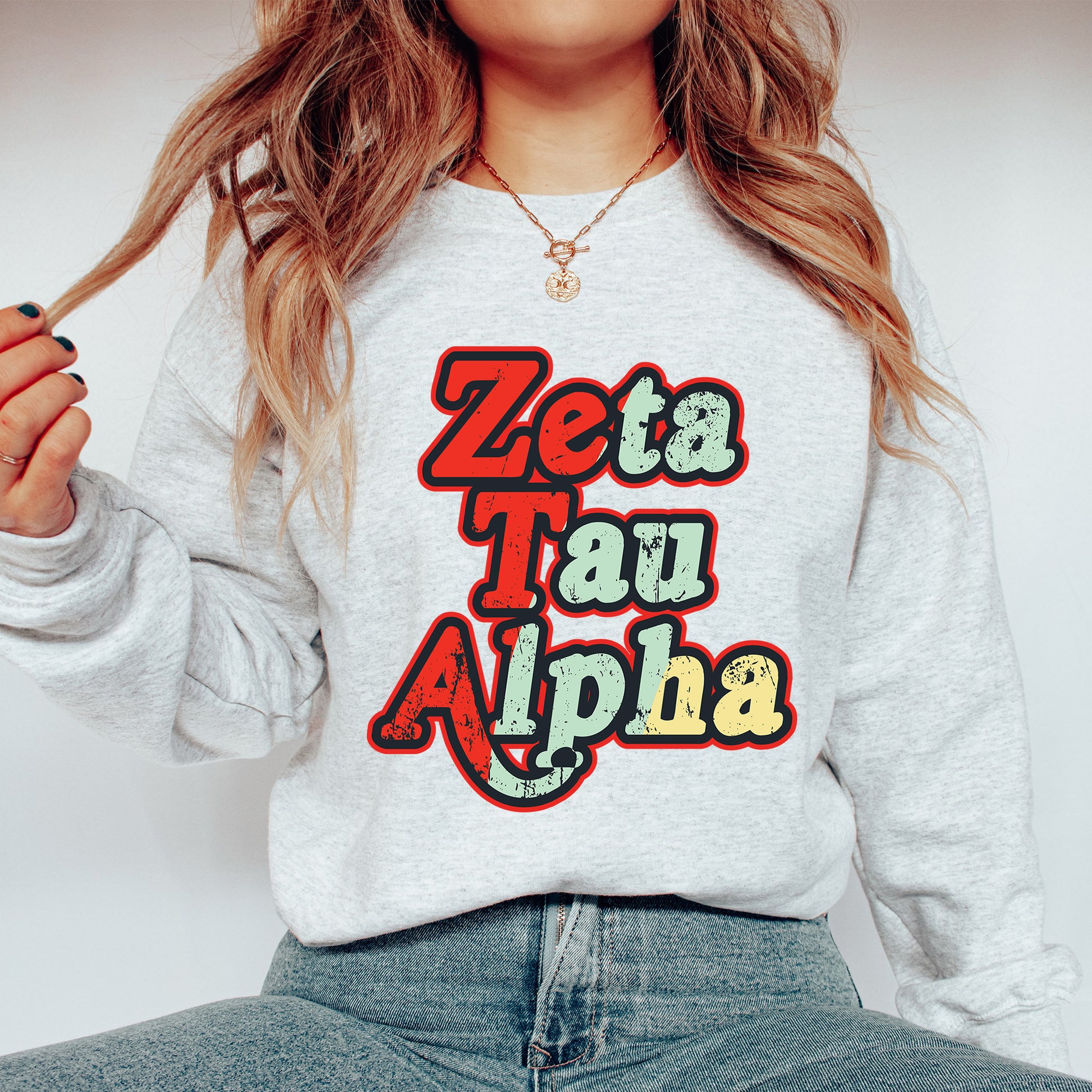 a woman wearing a sweatshirt that says zeta tau alpha