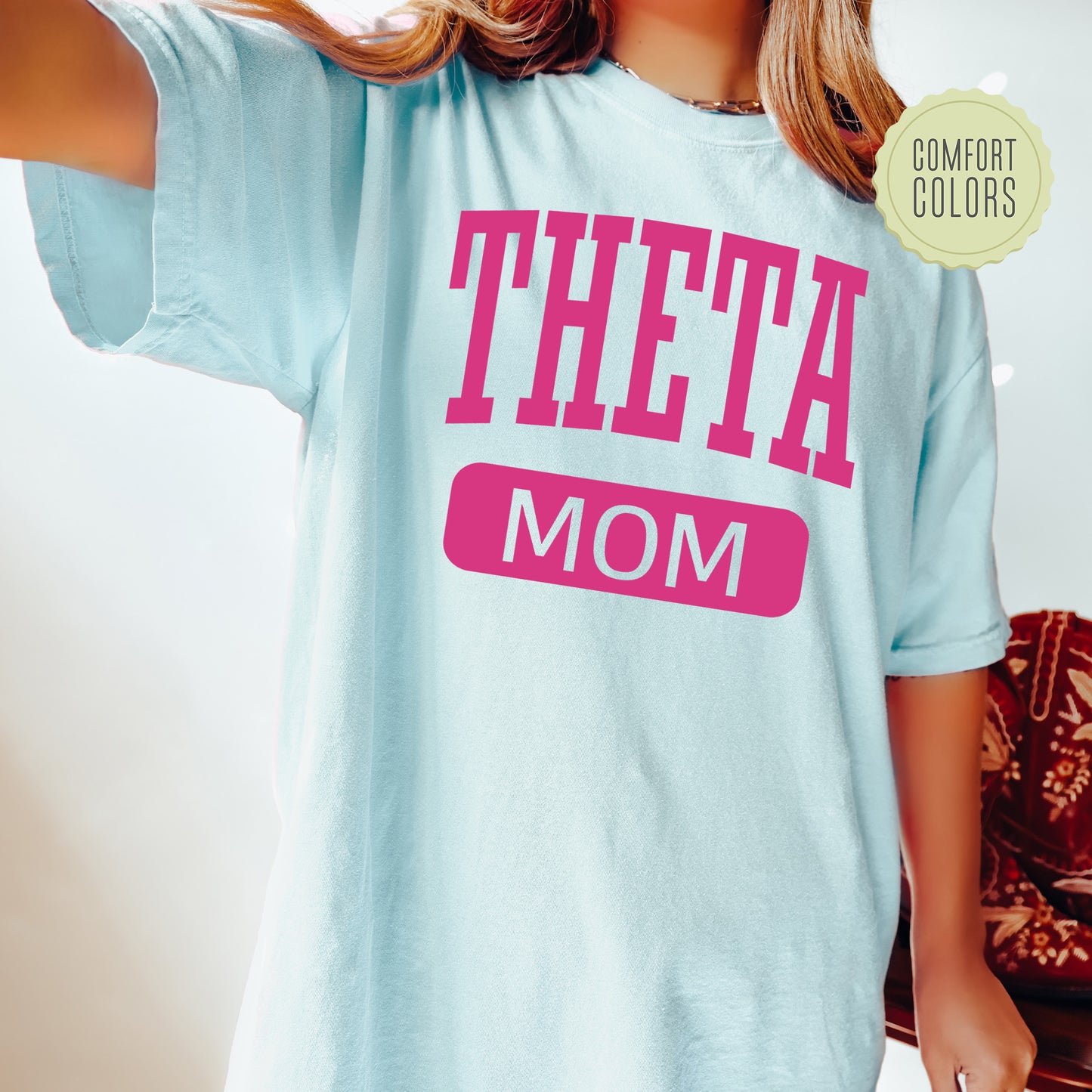 a woman wearing a t - shirt that says,'theta mom '