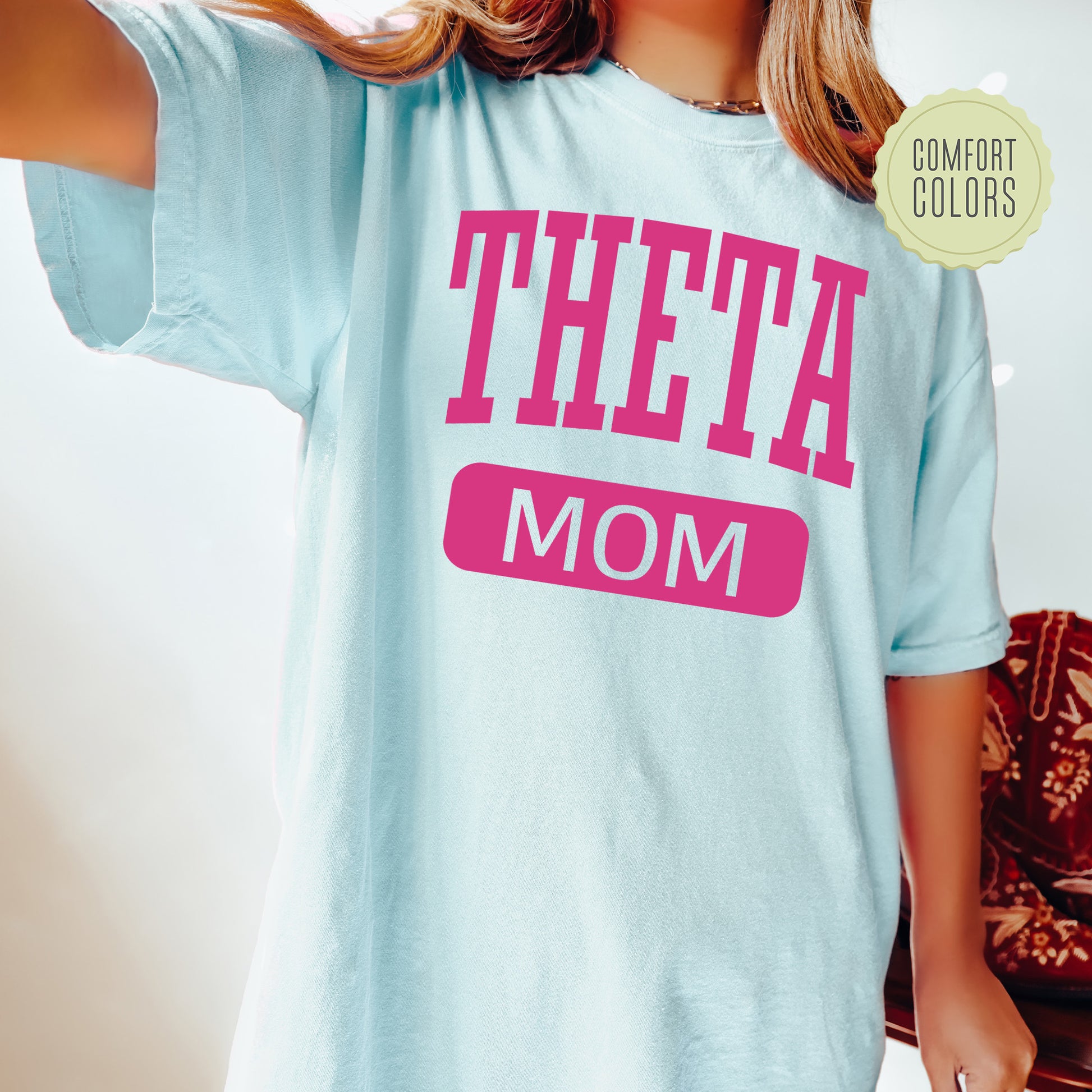 a woman wearing a t - shirt that says,'theta mom '