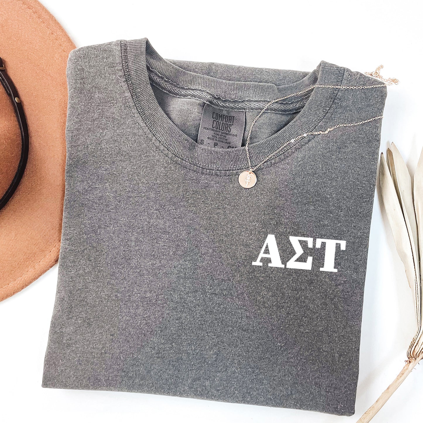 a hat, sunglasses, and a t - shirt on a white surface