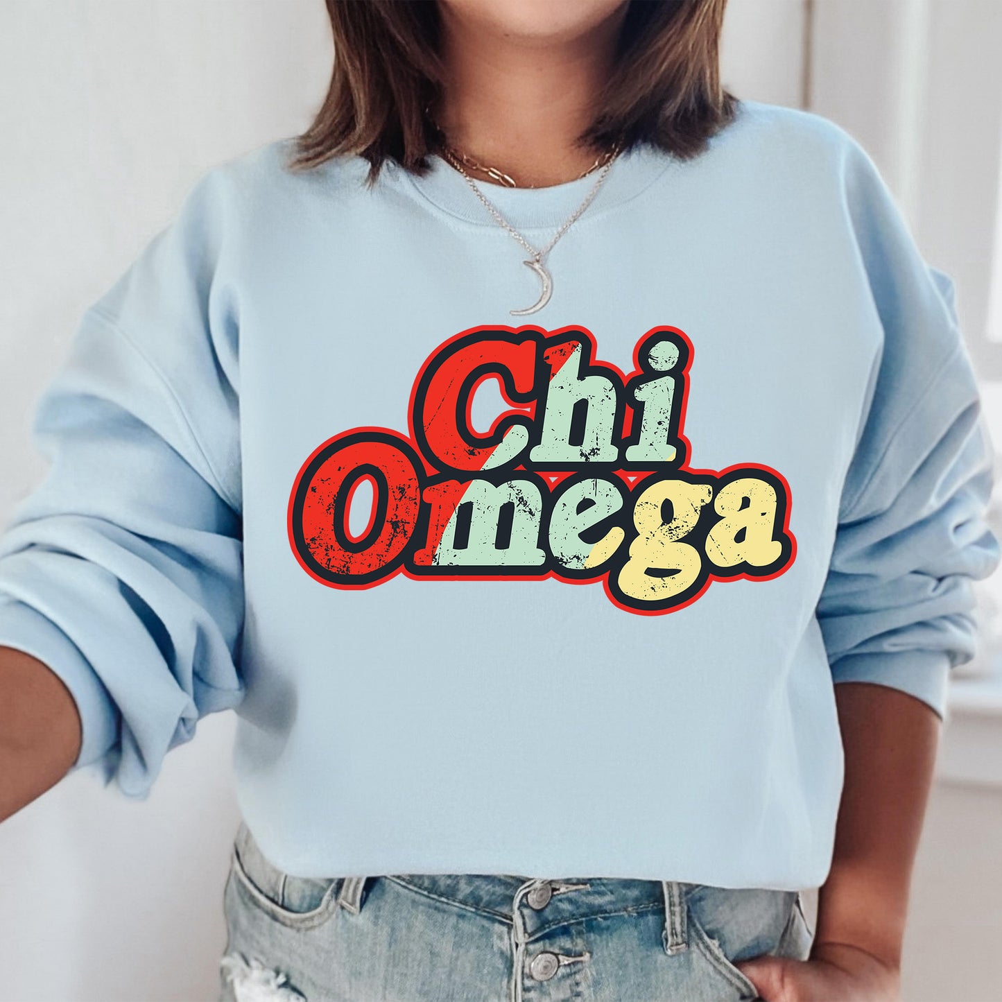 a woman wearing a blue sweatshirt with the word chi omega printed on it