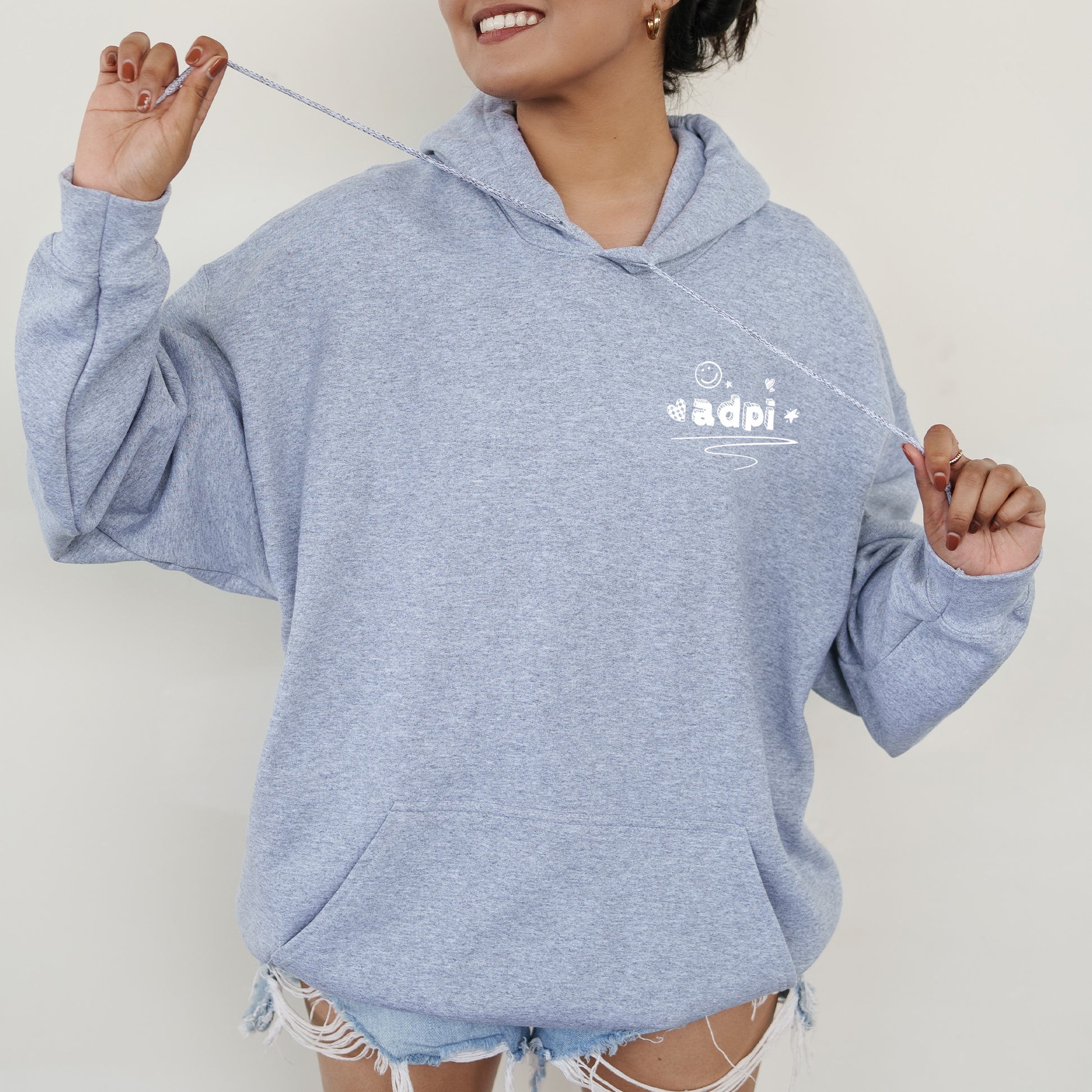 a woman in a blue hoodie holding a toothbrush