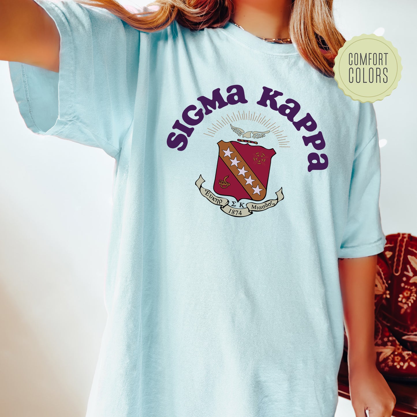 a woman wearing a light blue shirt with the words stigma karpp on it