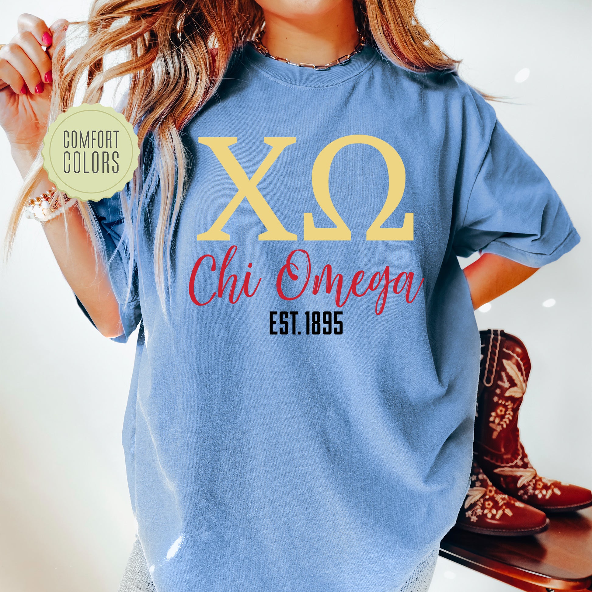 a woman wearing a blue shirt with a yellow x2 chi omega on it