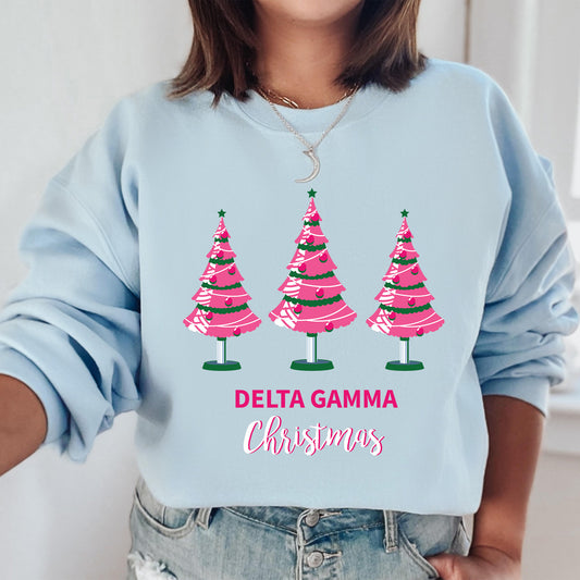 a woman wearing a blue sweatshirt with pink christmas trees on it