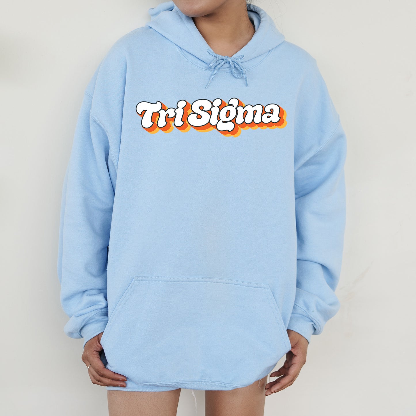 a person wearing a blue sweatshirt with the word tri stigma on it