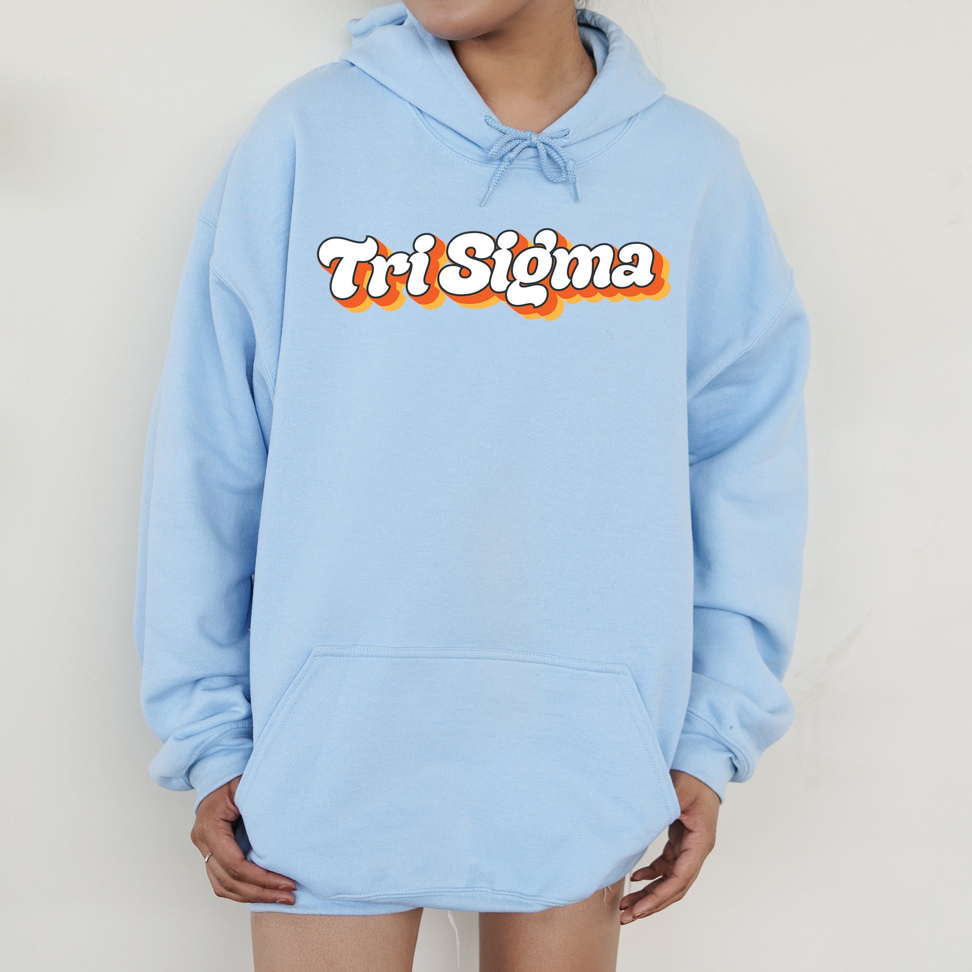 a person wearing a blue sweatshirt with the word tri stigma on it