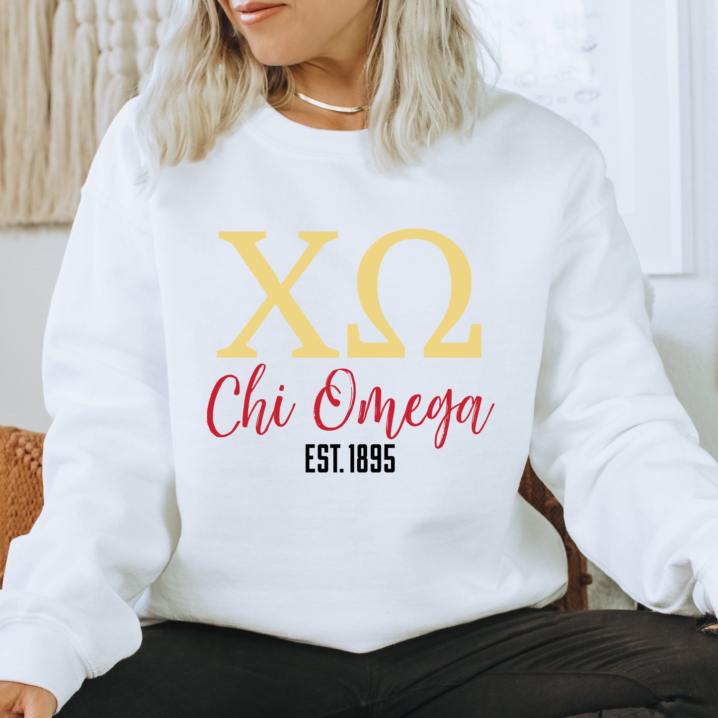 a woman sitting on a chair wearing a white sweatshirt