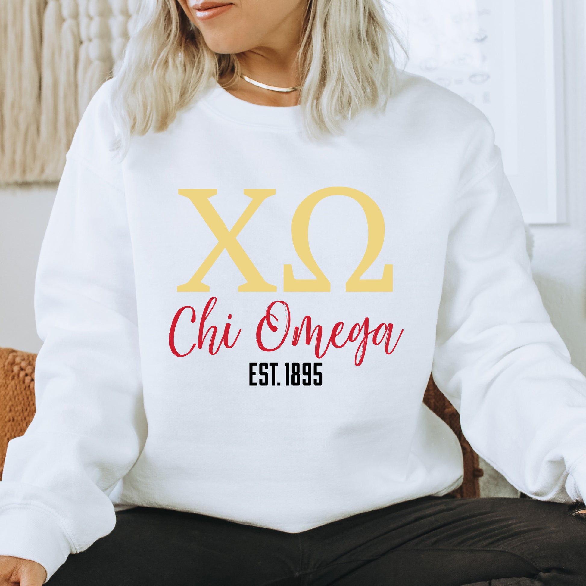 a woman sitting on a chair wearing a white sweatshirt
