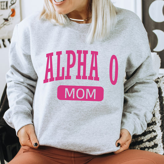 a woman sitting on a chair wearing a gray sweatshirt with pink letters