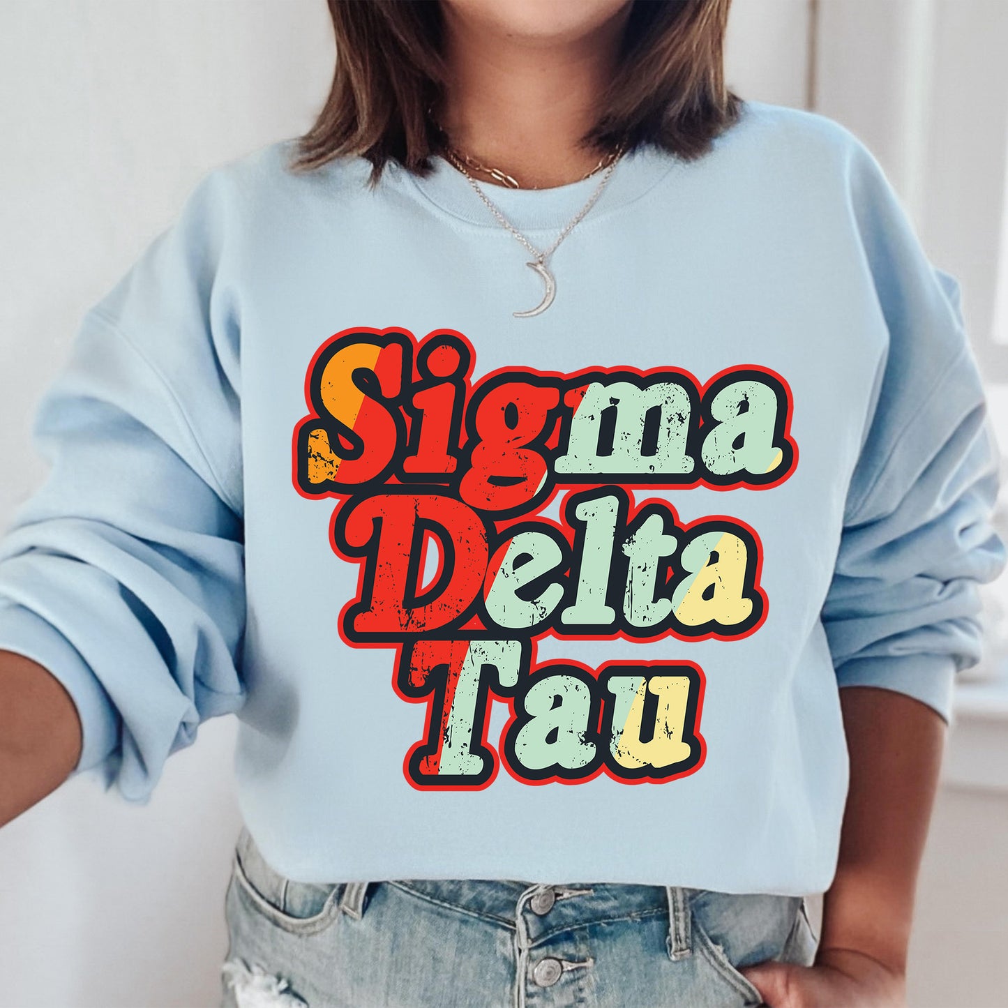 a woman wearing a blue sweatshirt with the words singma delta tau on it