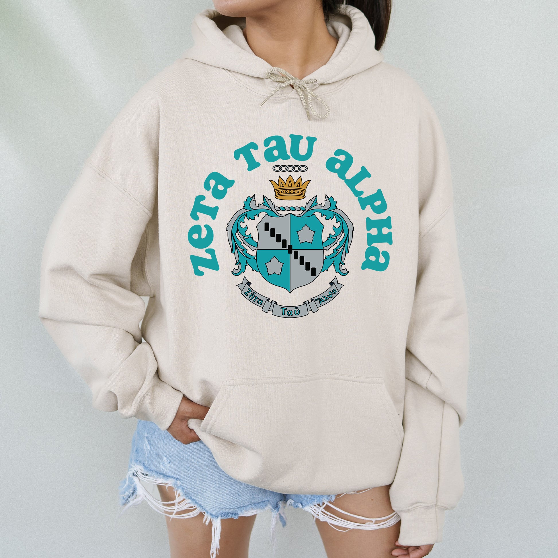 a woman wearing a white hoodie with a blue crown on it