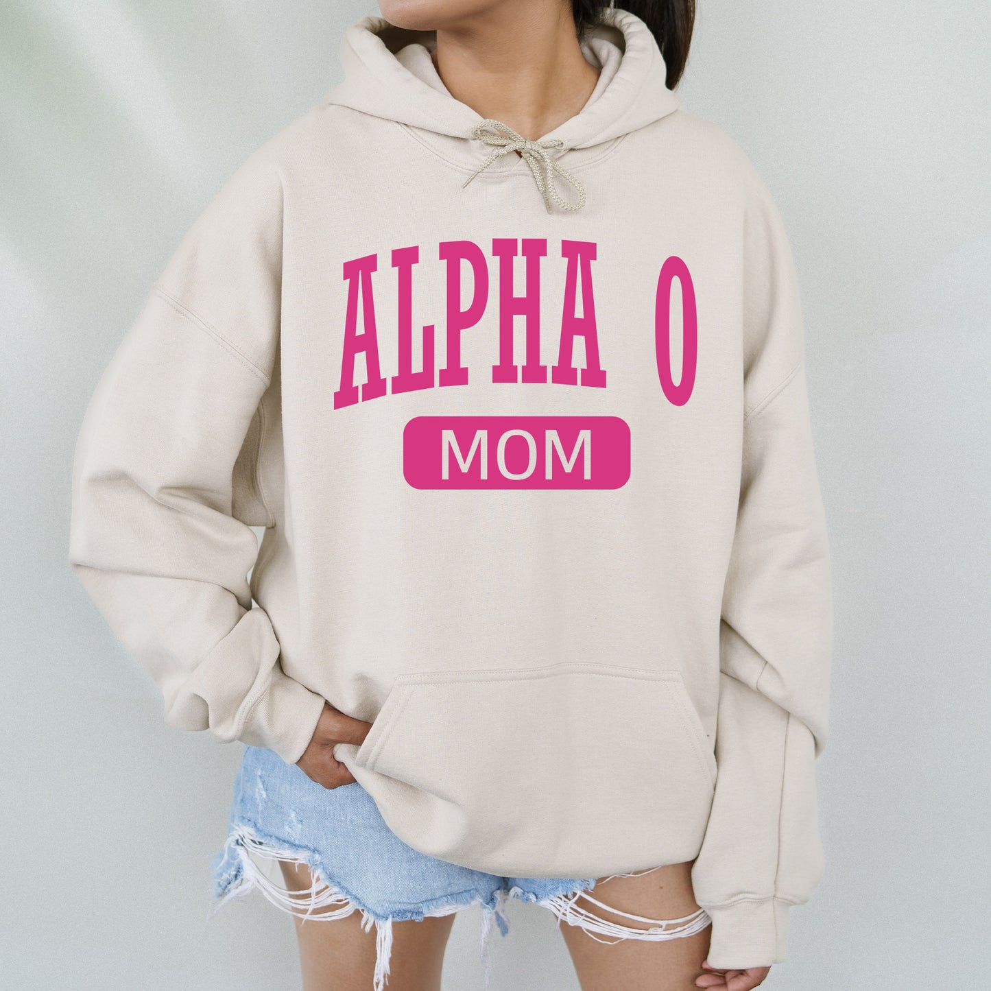 a woman wearing a sweatshirt that says,'alpha o mom '