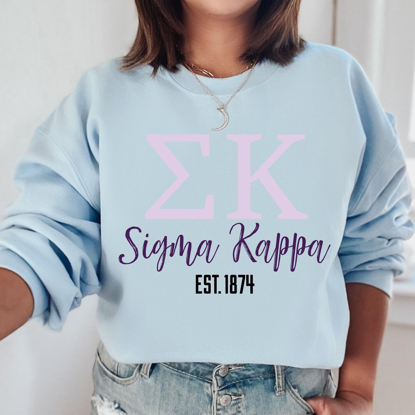 a woman wearing a blue sweatshirt with a pink zk on it