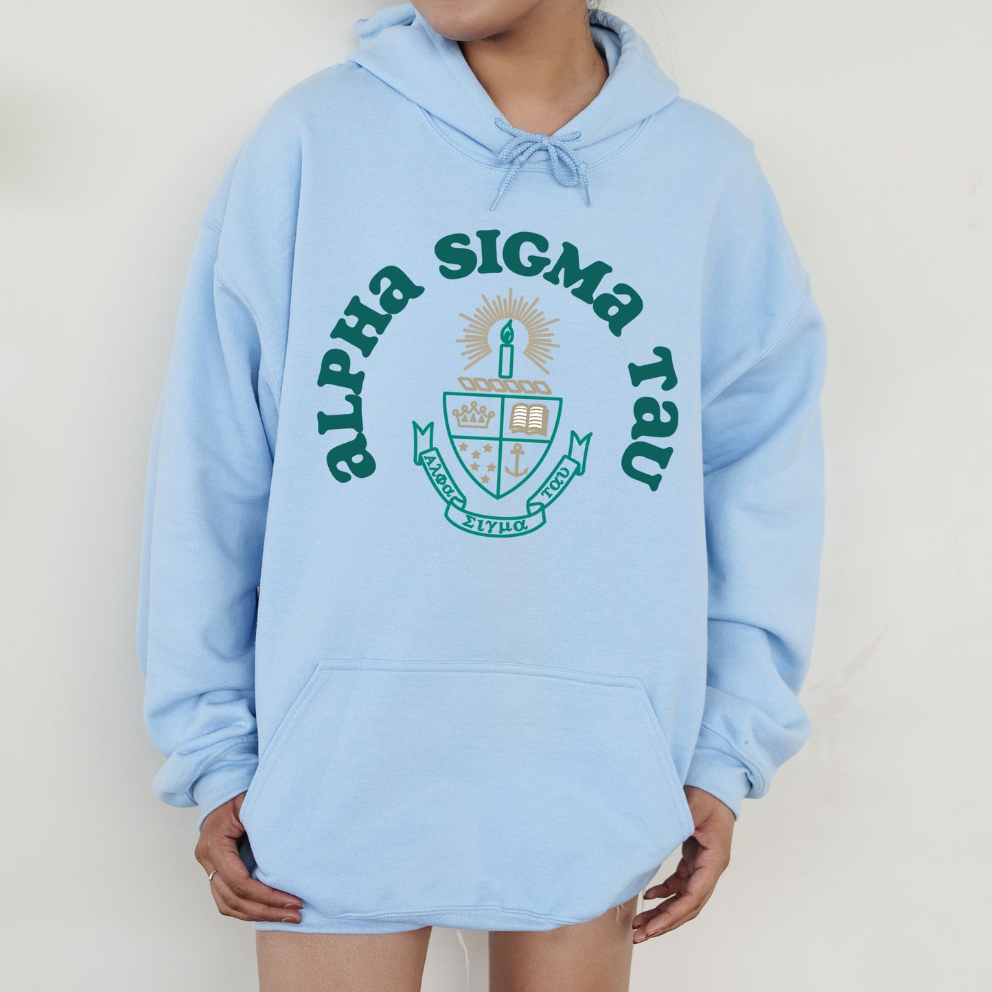 a person wearing a blue hoodie with a green and white logo