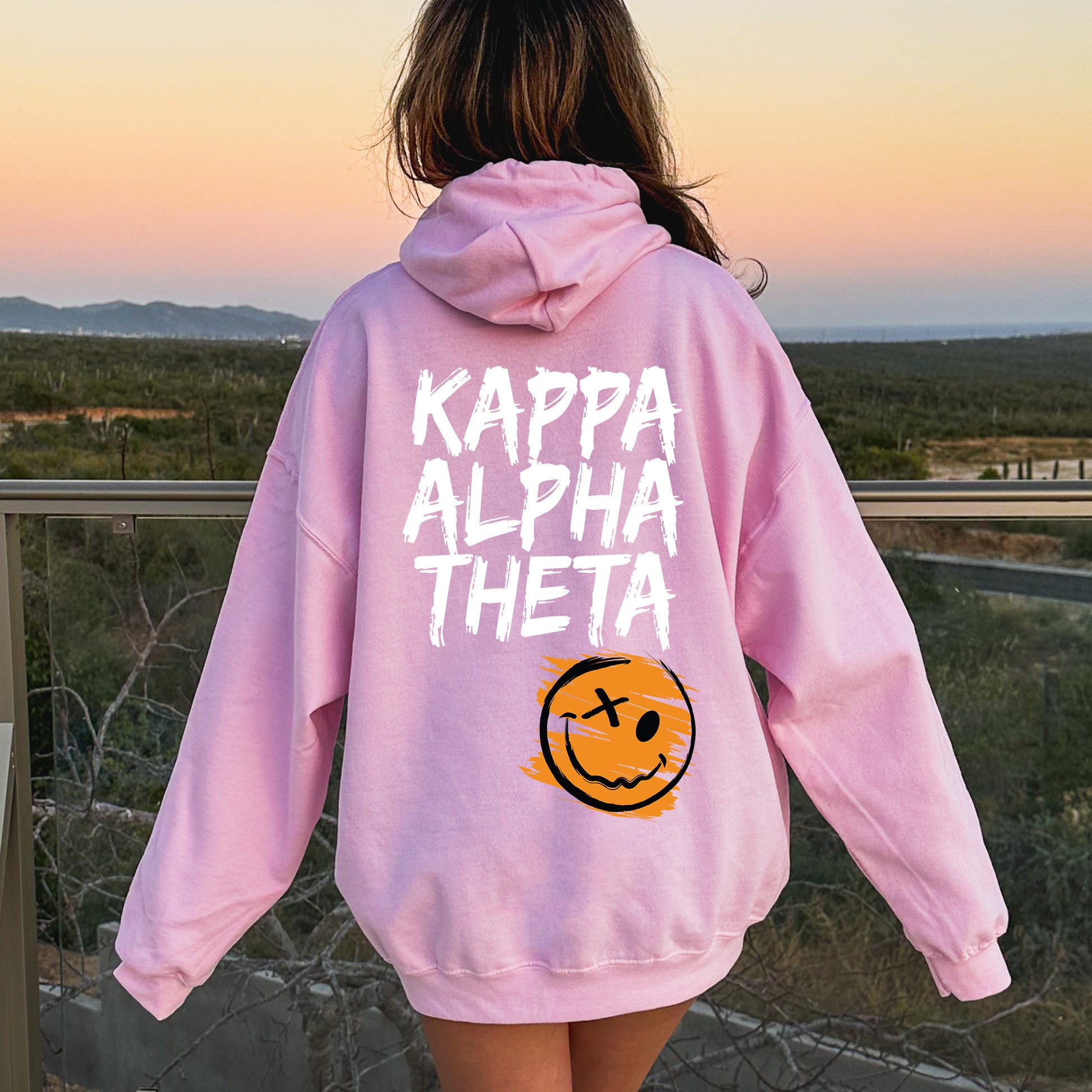 a girl in a pink hoodie that says kappa alpha the