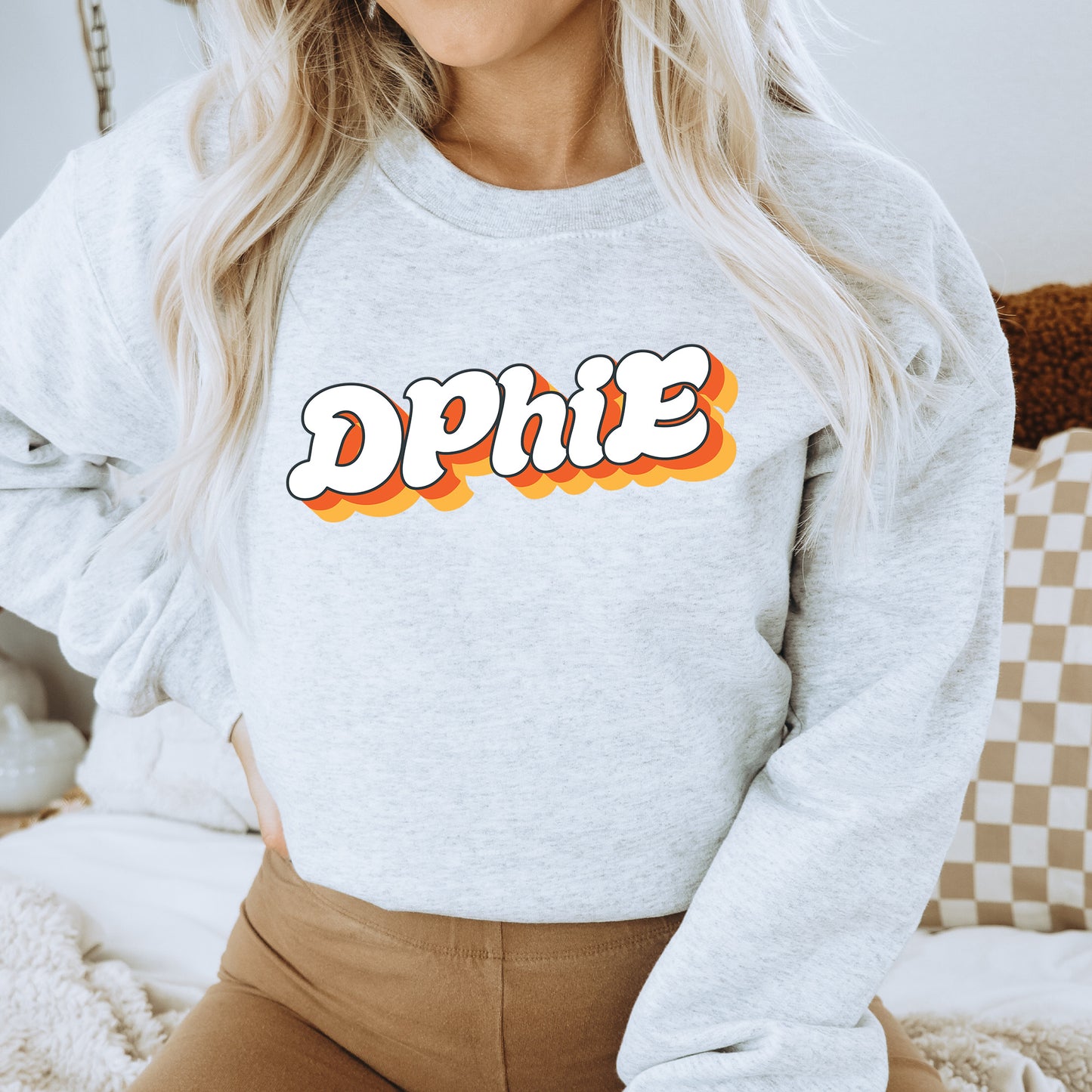 a woman wearing a grey sweatshirt with the word dppie on it