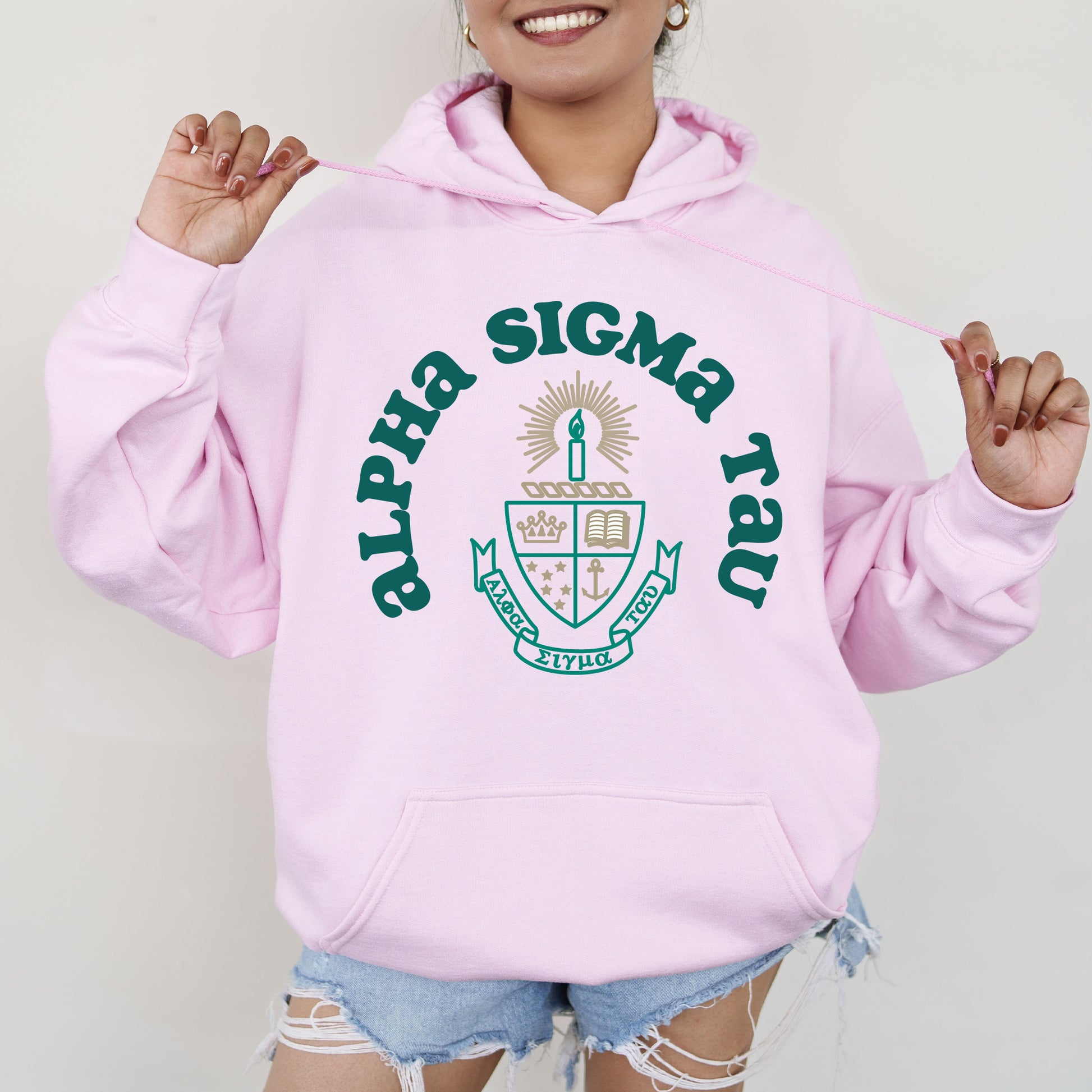 a woman wearing a pink sweatshirt and ripped shorts