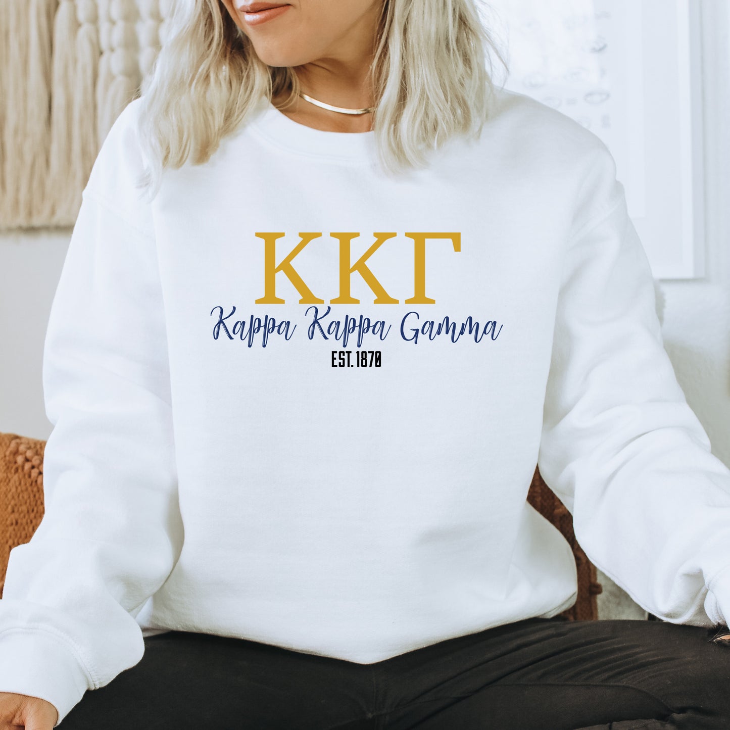 a woman sitting on a chair wearing a white sweatshirt